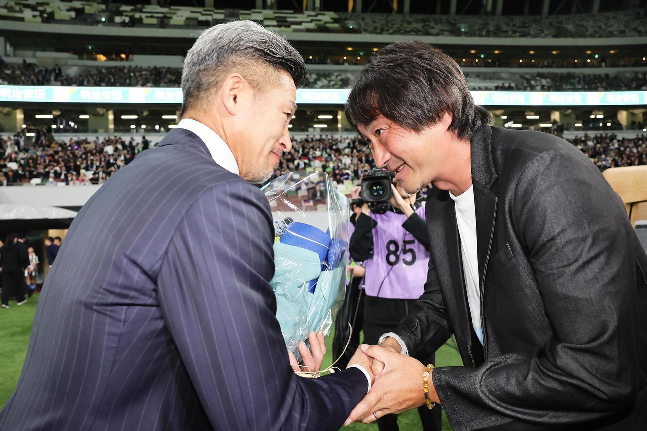 試合前、新宿北嶋監督（右）と握手を交わす鈴鹿カズ（撮影・足立雅史）