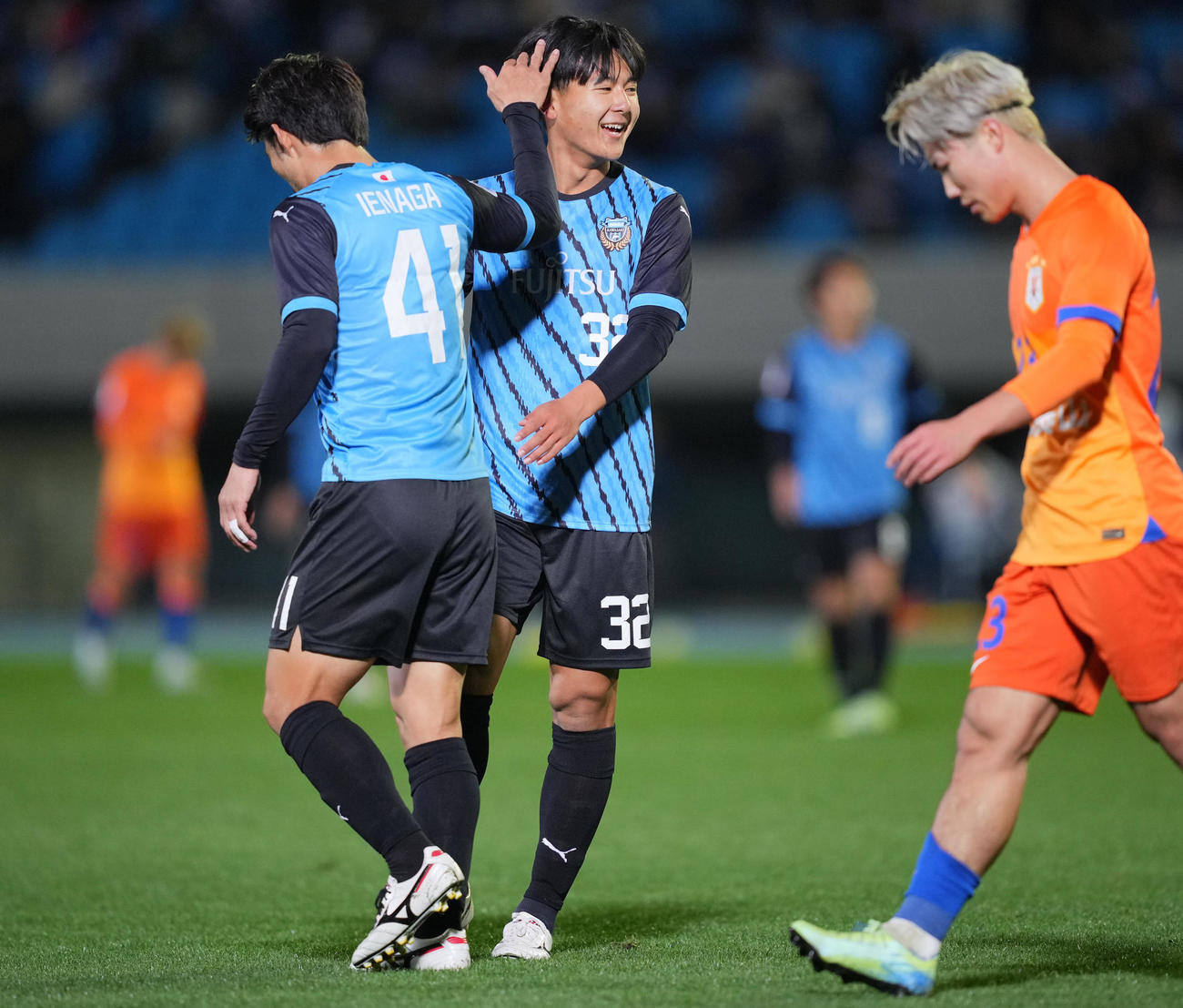 川崎F対山東泰山　後半、積極的な仕掛けに川崎F神田（中央）は家長（左）から頭をなでられ笑顔を見せる（撮影・垰建太）