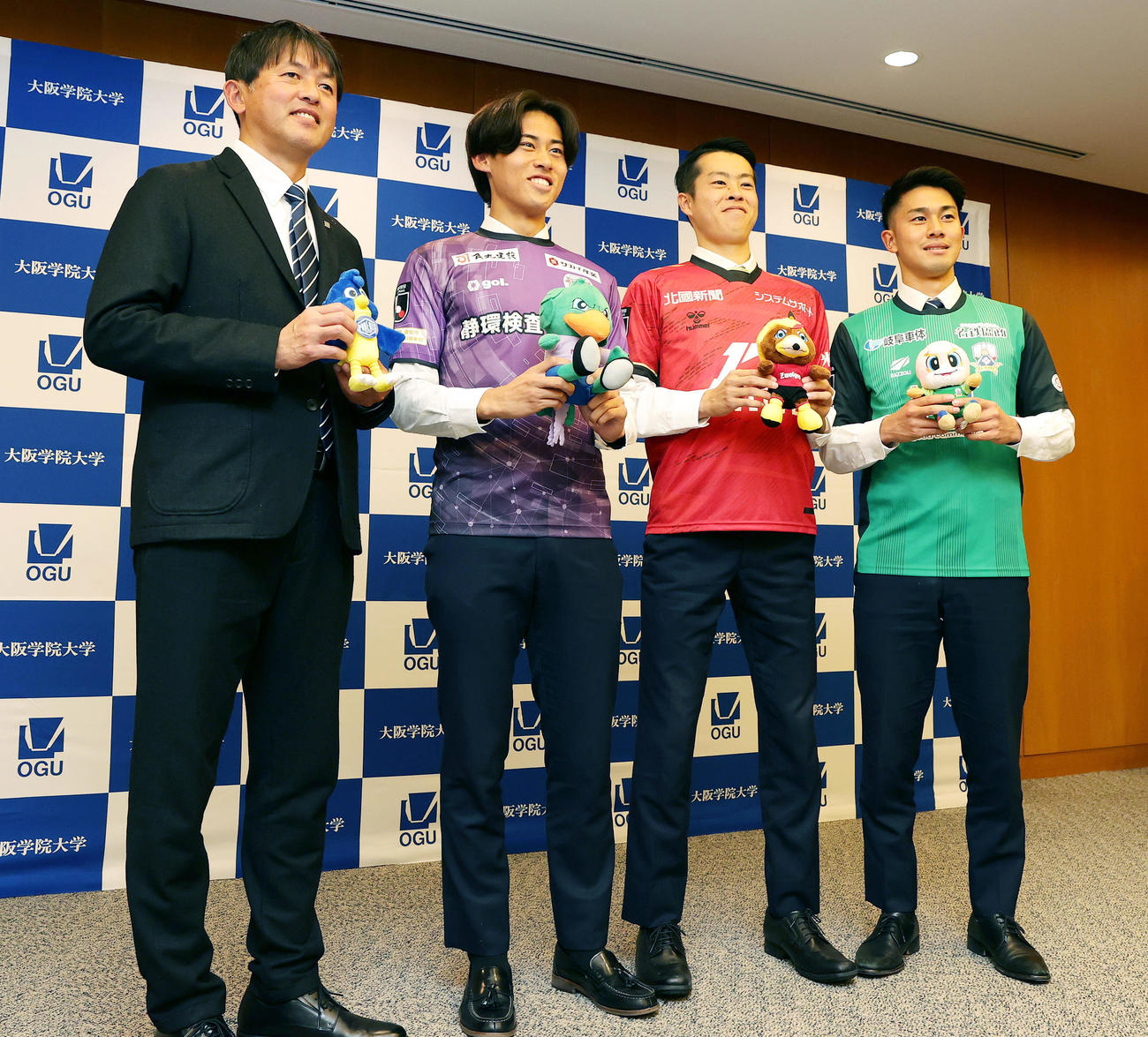 Jリーグクラブへの加入が内定し笑顔でフォトセッションに臨む、左から大院大・実好監督、藤枝に内定の閑田、金沢に内定の四宮、岐阜に内定の箱崎（撮影・前田充）