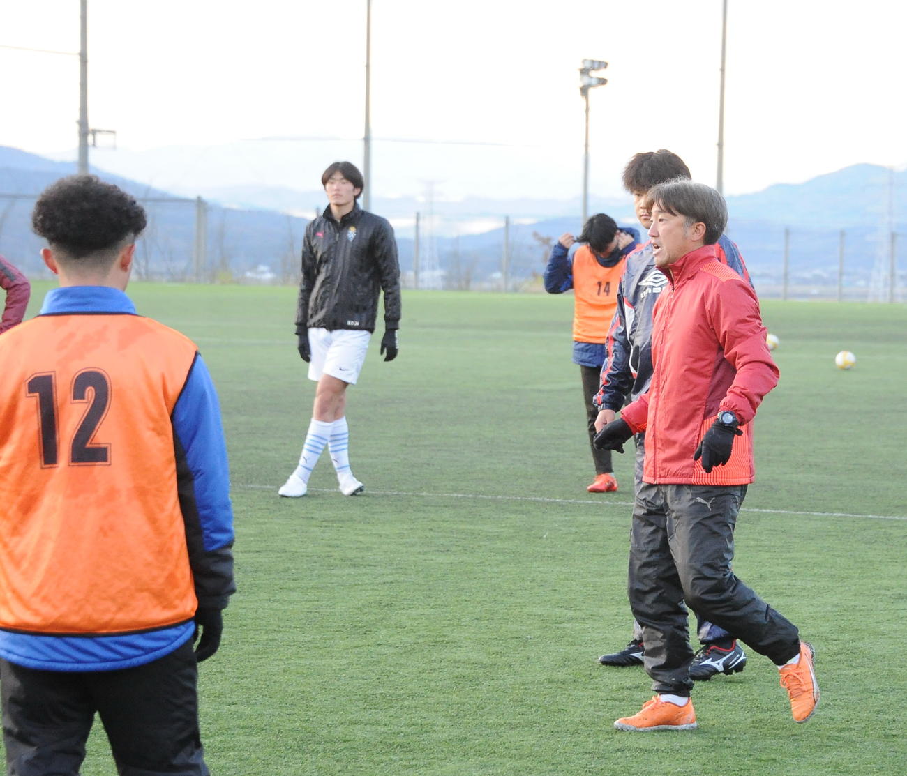 パスワークの練習で選手にアイデアを伝える新潟産大・岡村監督（右）（撮影・小林忠）