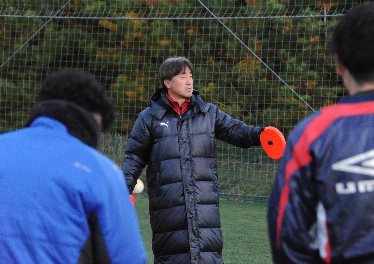 練習開始前に選手を集めて指示を出す新潟産大・岡村監督（中央）（撮影・小林忠）