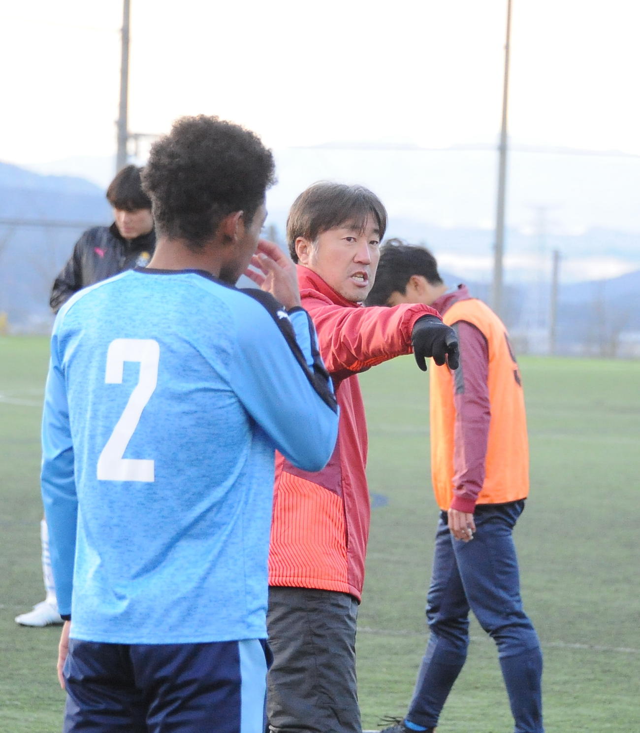パスワークの練習で選手にアイデアを伝える新潟産大・岡村監督（中央）（撮影・小林忠）