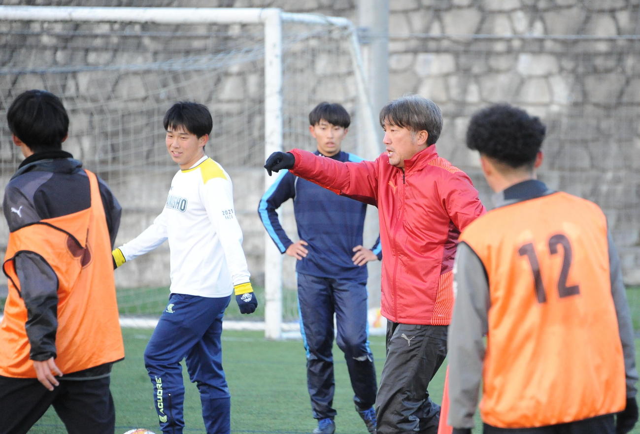 パスワークの練習で選手にアイデアを伝える新潟産大・岡村監督（右から2人目）（撮影・小林忠）