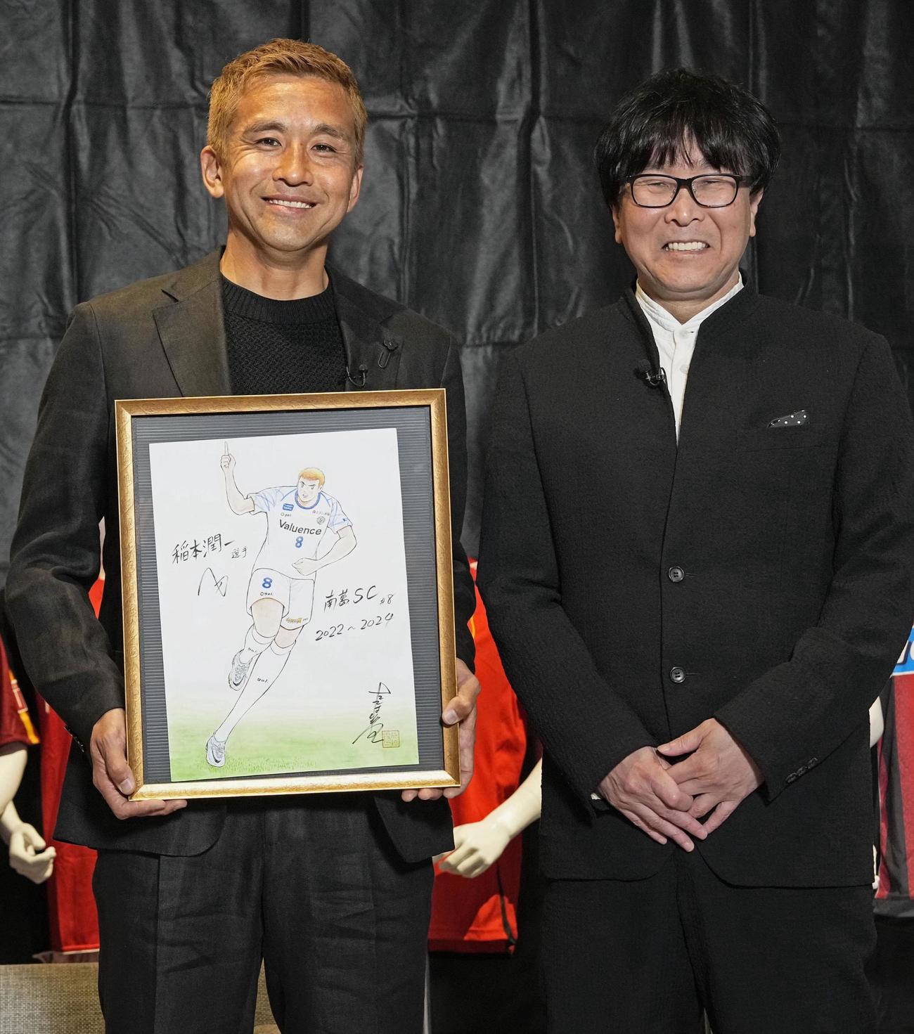 引退記者会見で高橋陽一氏からイラストを贈られた南葛SCの稲本潤一（共同）