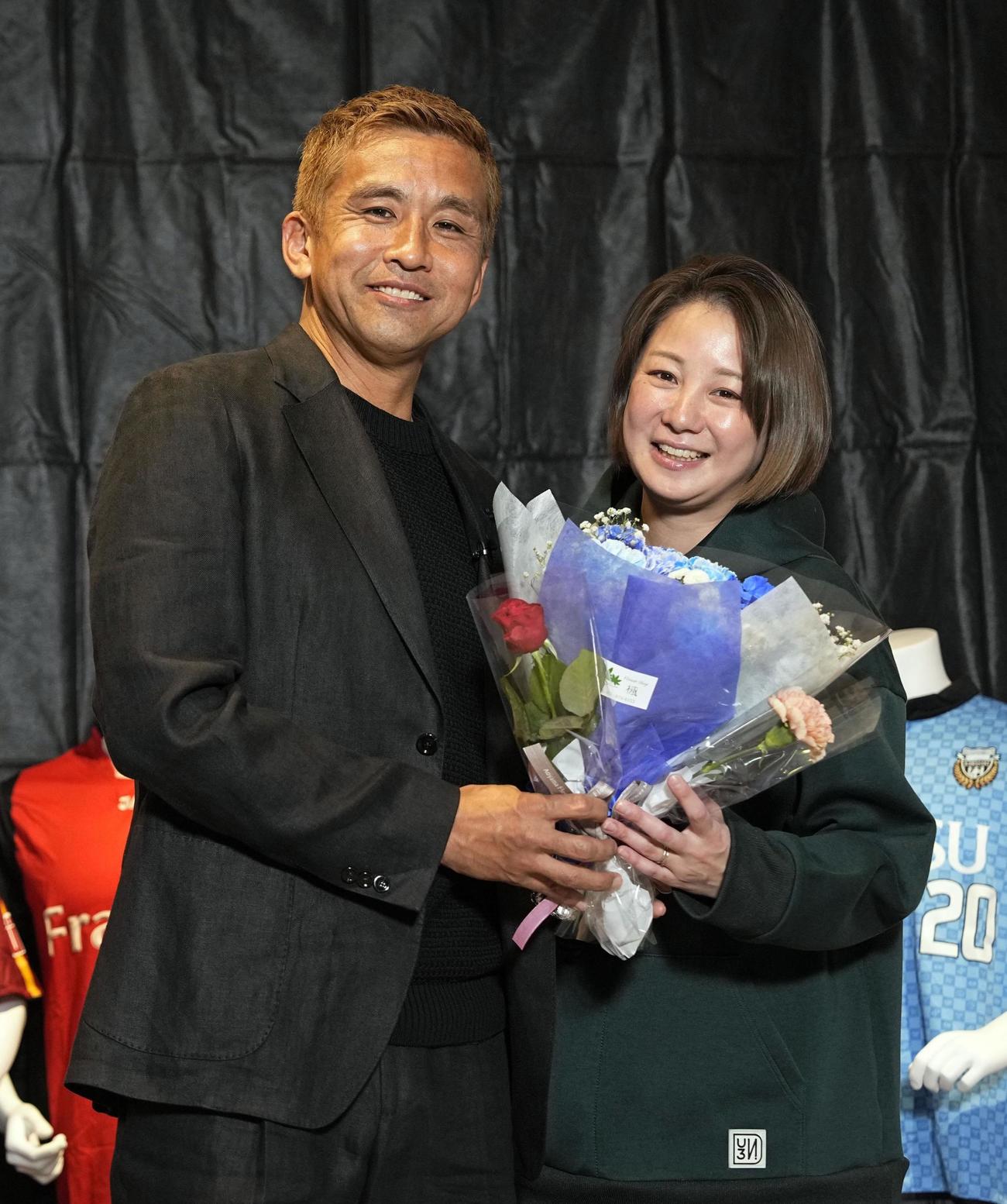 引退記者会見で妻の田中美保さんと写真に納まる南葛SCの稲本潤一（共同）