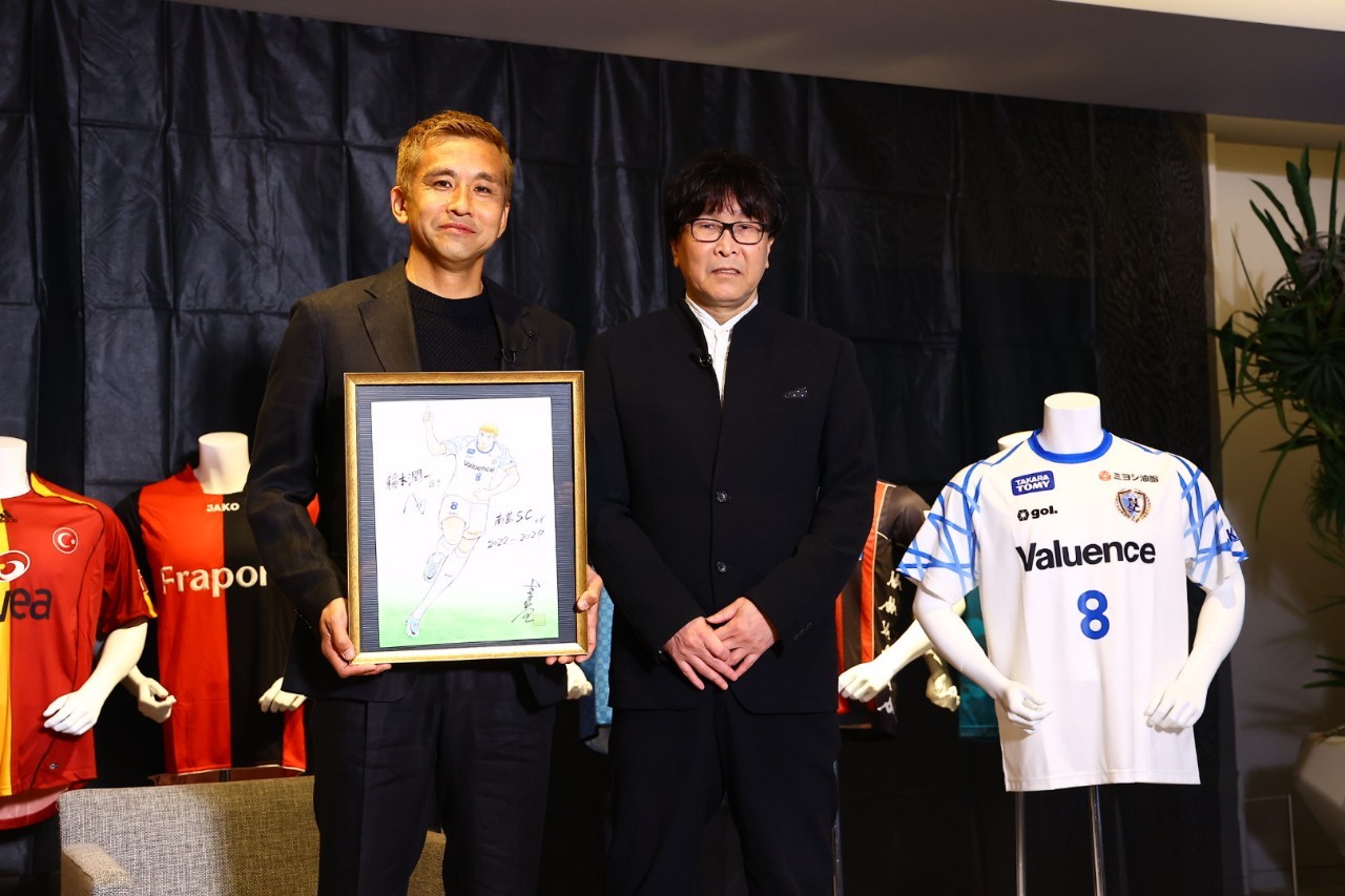 引退会見を開いた元日本代表MF稲本潤一は、南葛SCオーナーの高橋陽一氏からイラストを贈られて笑顔で記念撮影（C）南葛SC／松岡健三郎