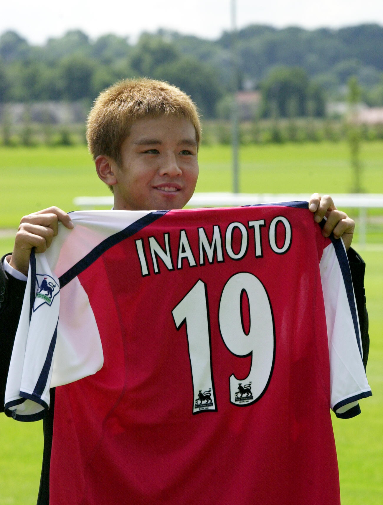 2001年7月、アーセナル入団会見を終え、報道陣に19番のユニホームを披露する稲本