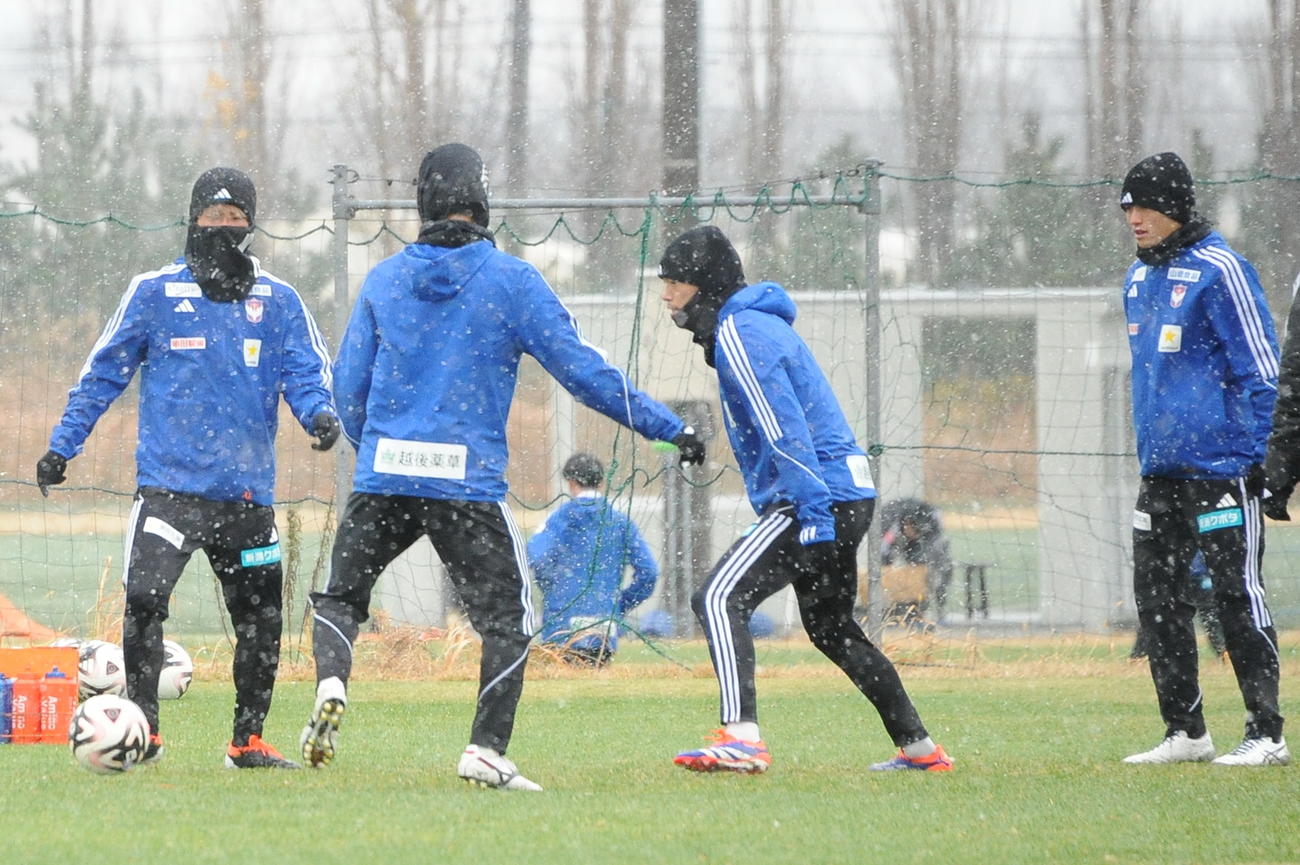 雪が舞う中、浦和戦前日練習を行う新潟の選手たち（撮影・小林忠）