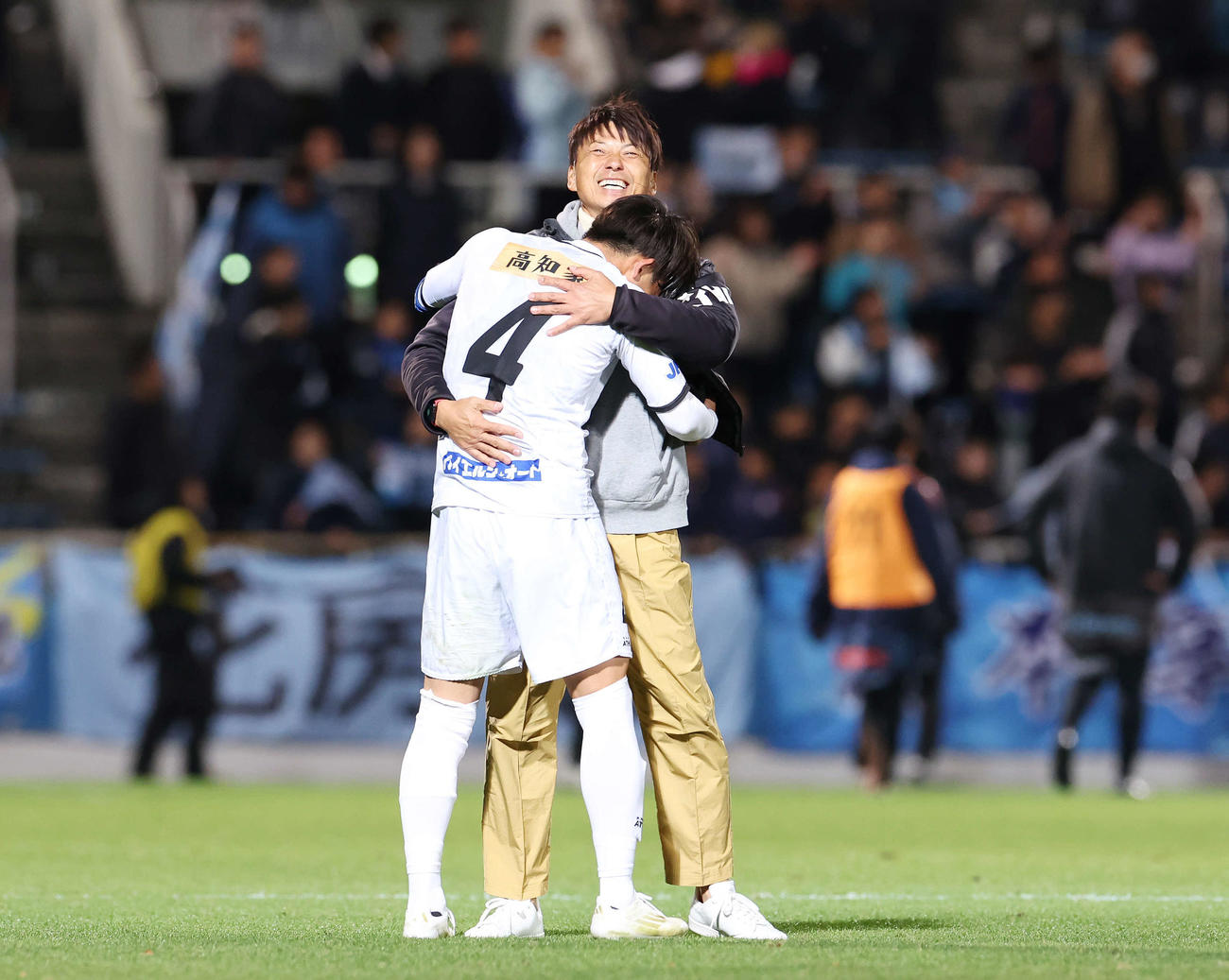 YS横浜対高知ユナイテッド　勝利しJ3参入を決め高知ユナイテッド小林大（手前）と抱き合う吉本監督（撮影・宮地輝）