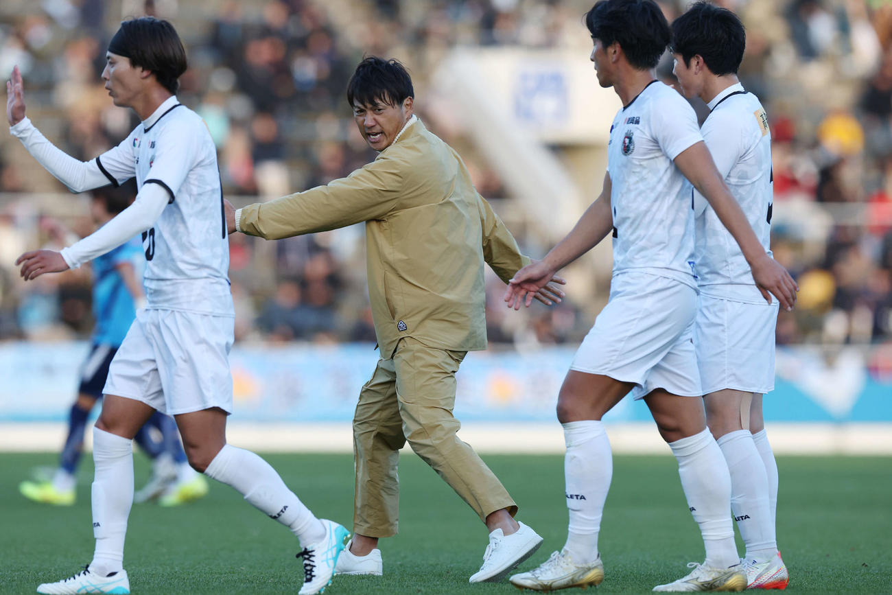 YS横浜対高知ユナイテッド　前半を終え、高知ユナイテッド田辺（右）に身ぶり手ぶり指示する吉本監督（中央左）（撮影・宮地輝）