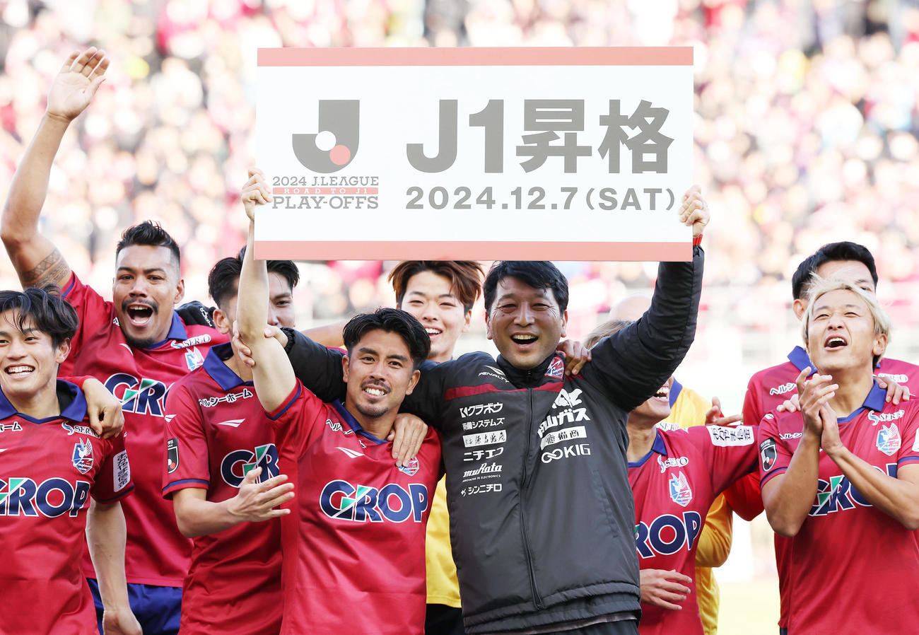 岡山対仙台　J1昇格を果たし、ボードを掲げて歓喜する竹内（中央左）と木山監督（同右）ら岡山の選手たち（撮影・前田充）