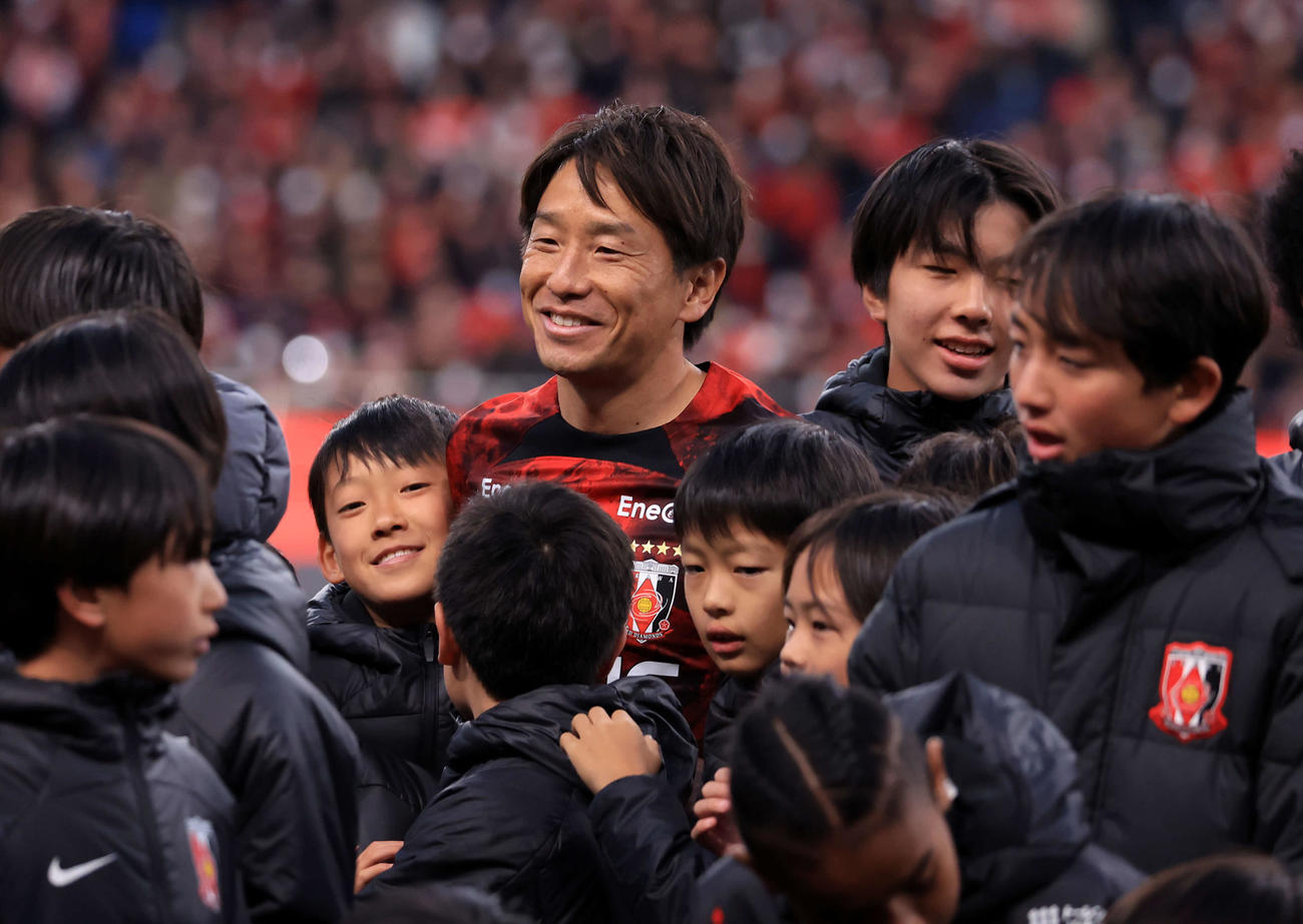 浦和対新潟　引退セレモニーでアカデミーの子どもたちに囲まれ笑顔の浦和宇賀神（撮影・浅見桂子）