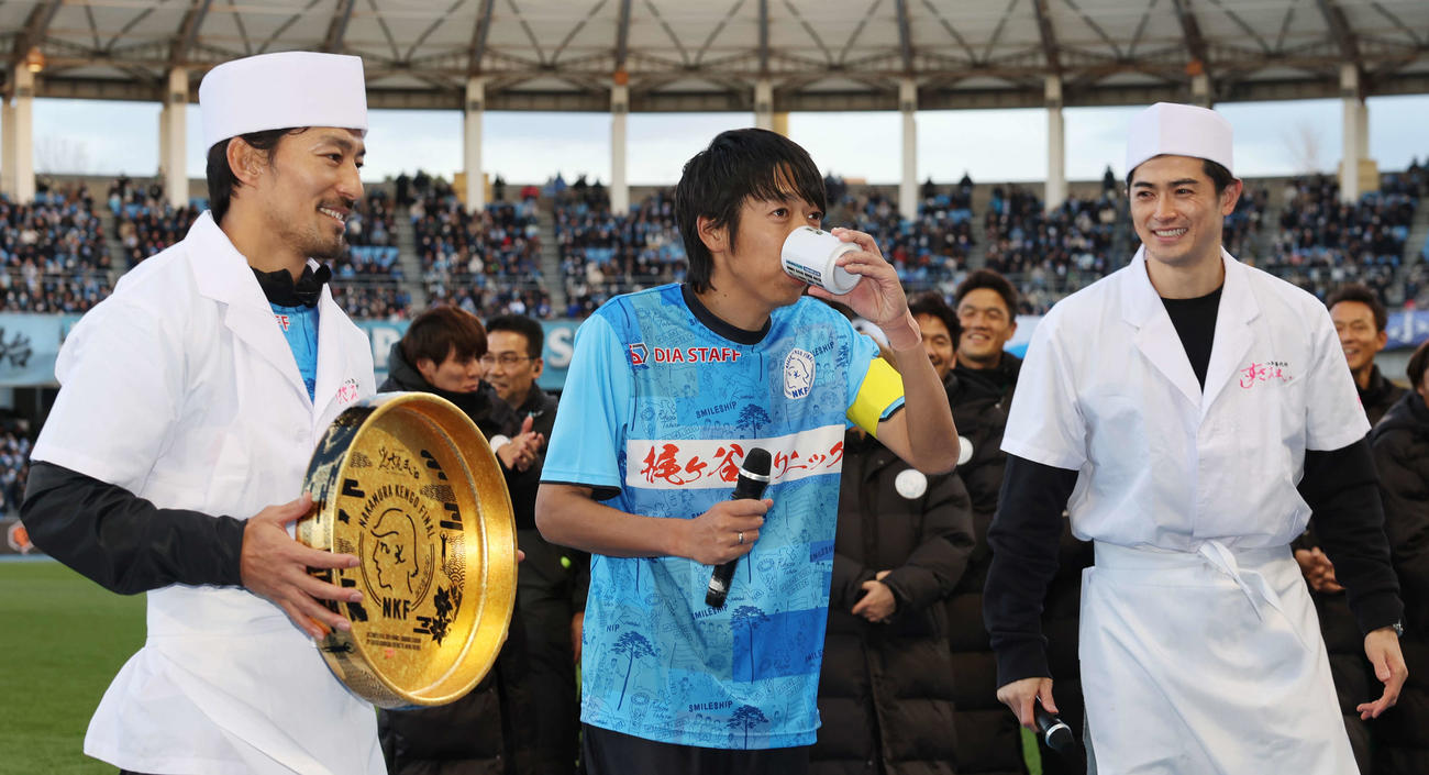 中村憲剛引退試合　試合後、谷口彰悟（右）からのあがりを飲む中村憲剛。左は家長昭博（撮影・宮地輝）