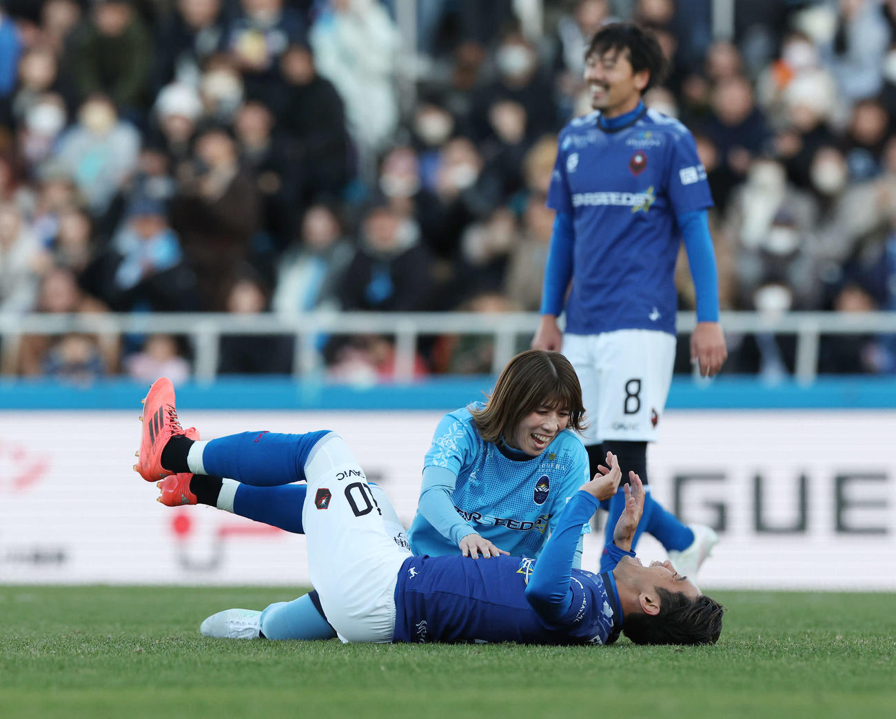 松井大輔引退試合　MATSUI FRIENDS対JAPAN DREAMS　後半、香川真司（下）をタックルし笑顔の吉田沙保里。後方松井大輔（撮影・宮地輝）