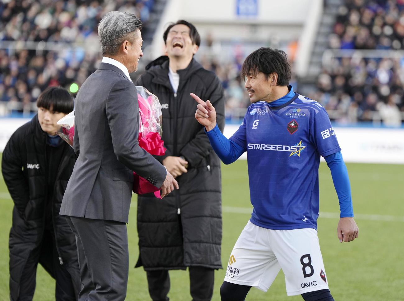 松井大輔引退試合　花束贈呈の際、自分の前を通り過ぎた鈴鹿・三浦（手前左）を呼び止める松井大輔（右）（共同）