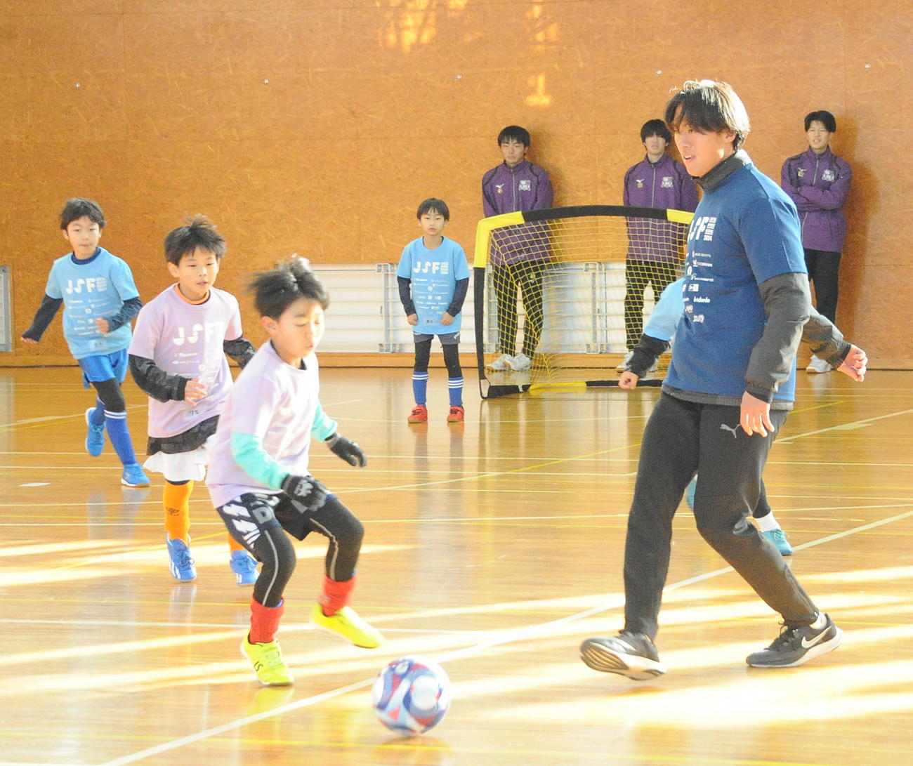 サッカー教室でパスを出す来季富山に加入する法大・竹内（右）（撮影・小林忠）