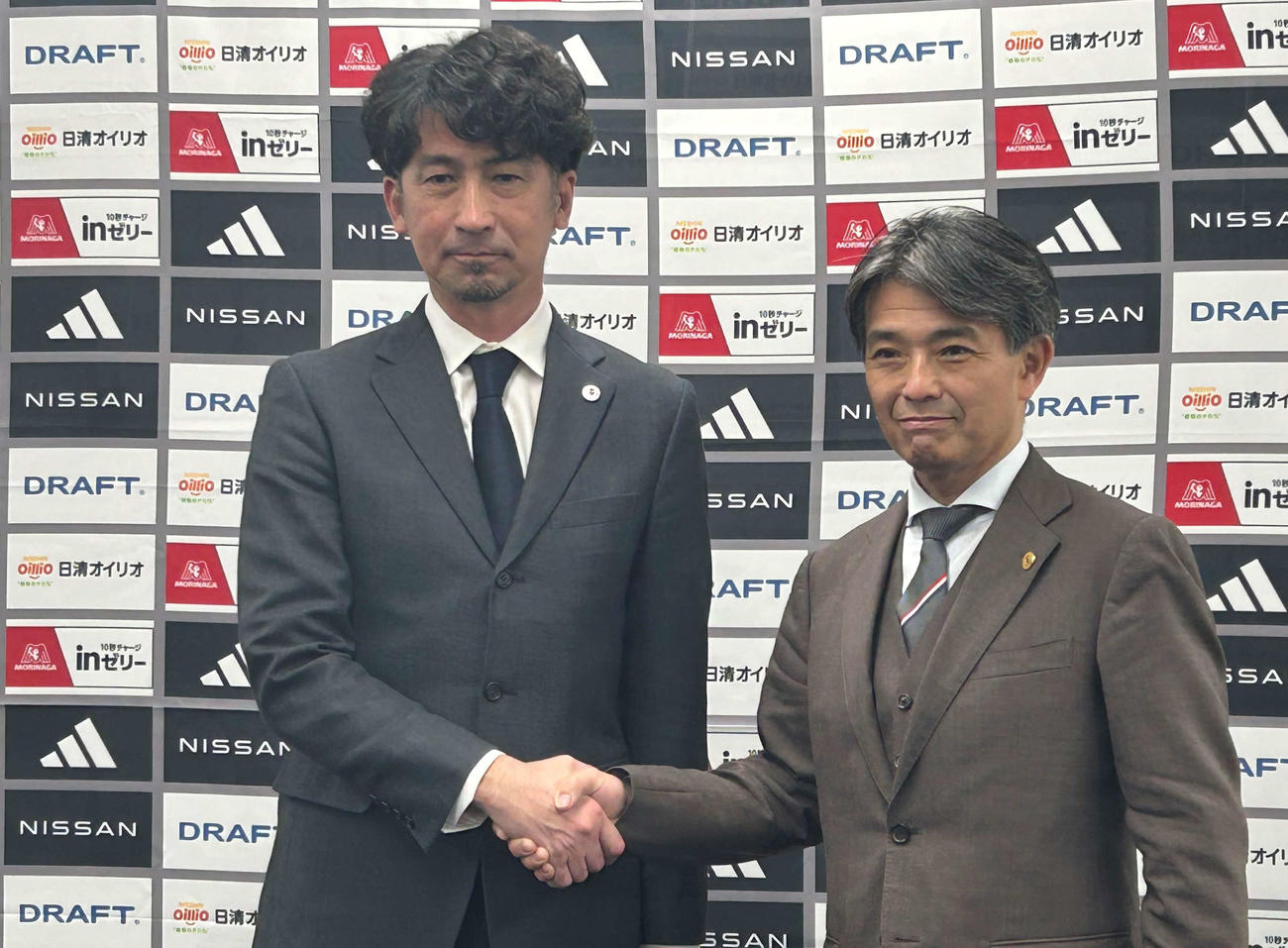 西野努氏（左）は中山昭宏社長とがっちり握手する