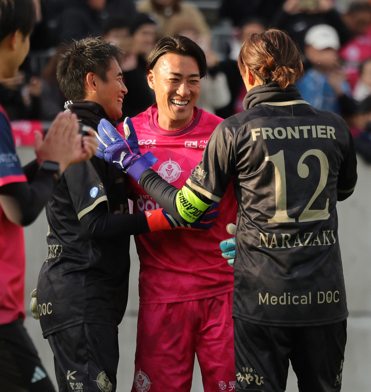 南雄太引退試合　YUTA FRIENDS対BLUE LEGENDS PK戦の末勝利し、BLUE LEGENDSのGK川口（左）、楢崎（右）と抱きあうYUTA FRIENDS南（撮影・野上伸悟）