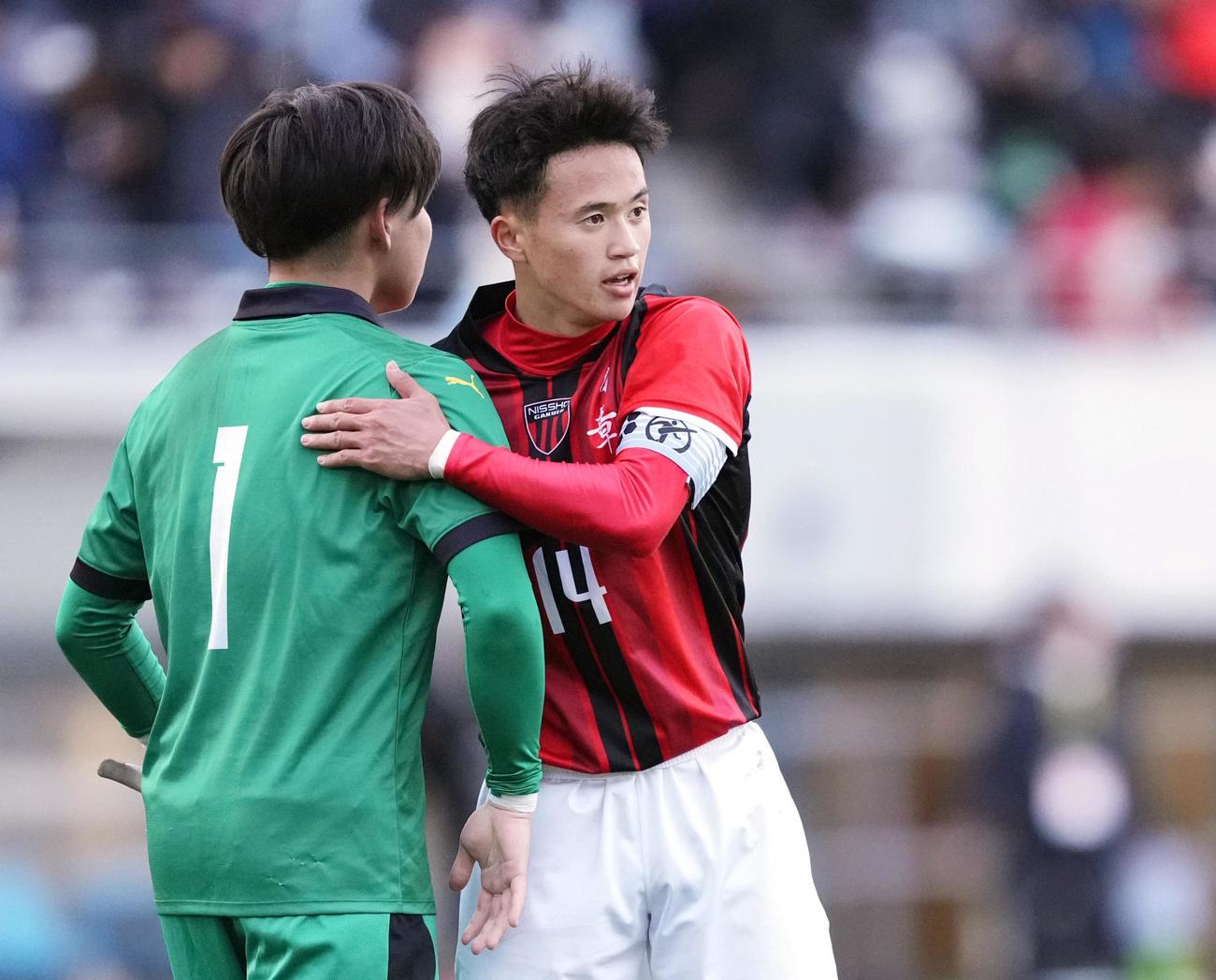 西目に勝利し、健闘をたたえ合う日章学園・高岡（右）（共同）