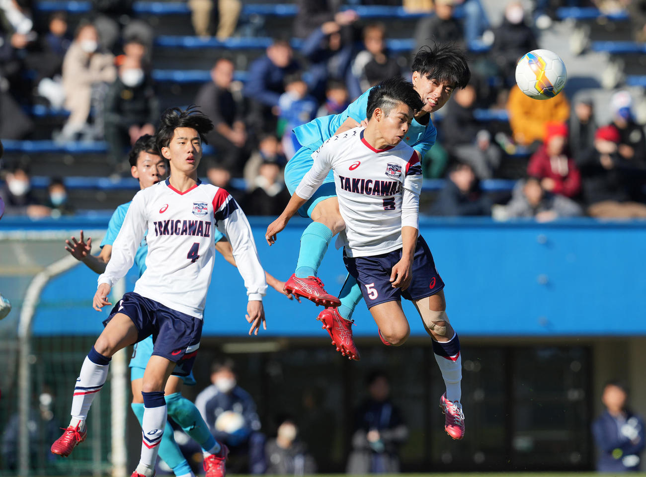 滝川二対山梨学院　前半、ヘディンで競り合う山梨学院・小河原（中央）と滝川二・酒井（撮影・垰建太）