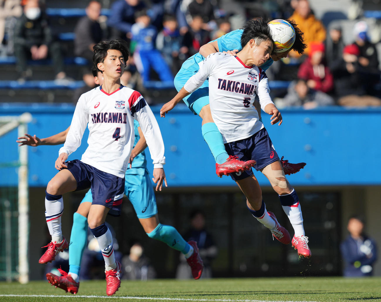 滝川二対山梨学院　前半、ヘディンで競り合う山梨学院・小河原（中央）と滝川二・酒井（撮影・垰建太）