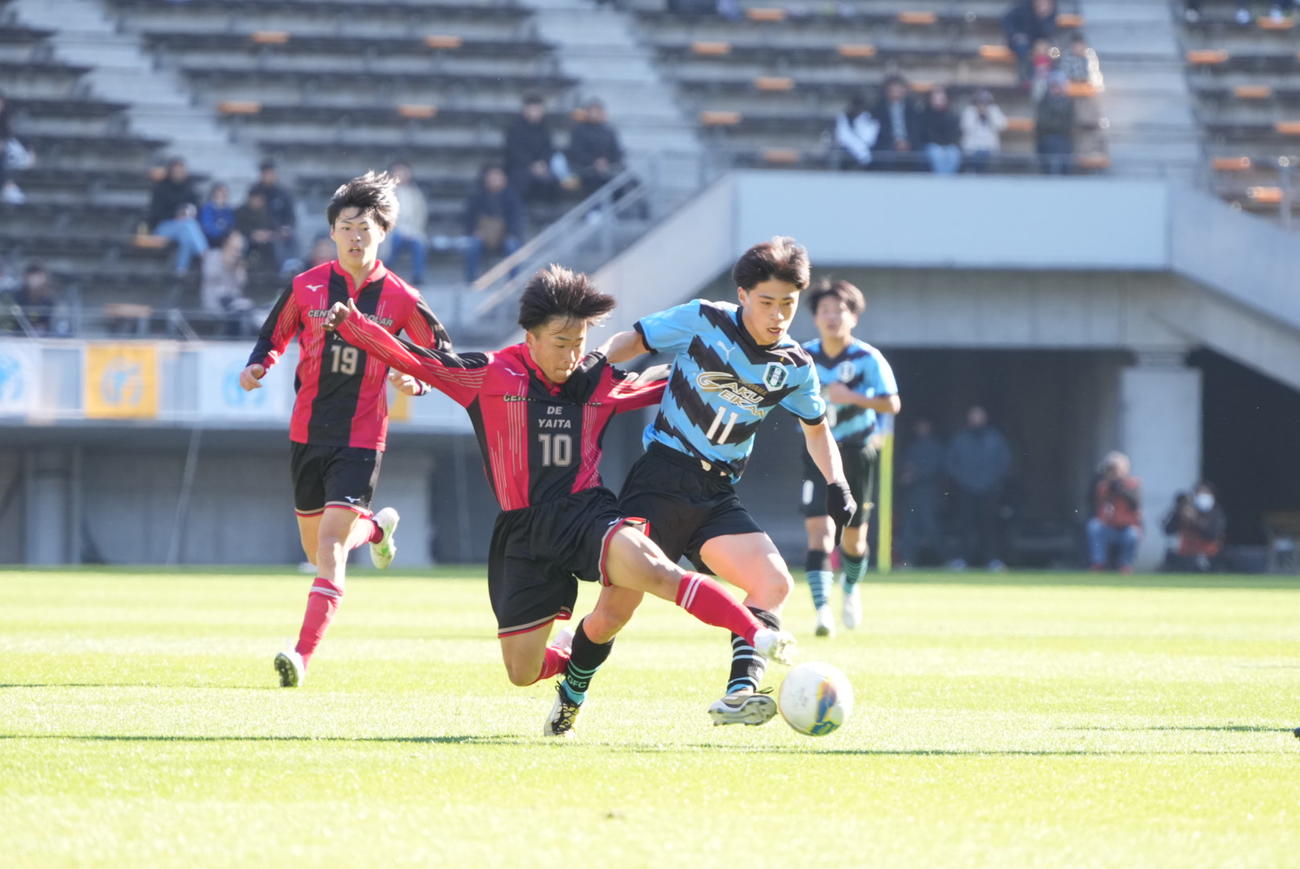 全国高校サッカー選手権大会　矢板中央対岡山学芸館　前半、岡山学芸館・万代（右）な矢板中央・堀内にドリブル突破を阻まれる（撮影・小沢裕）