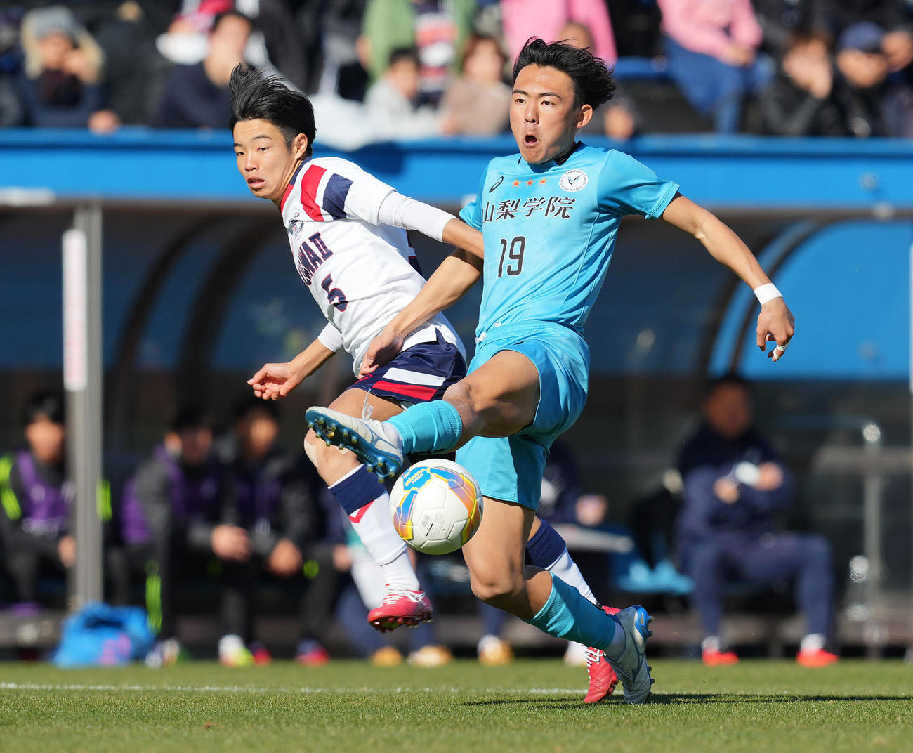 滝川二対山梨学院　前半、競り合う山梨学院・阿部（右）と滝川二・酒井（撮影・垰建太）