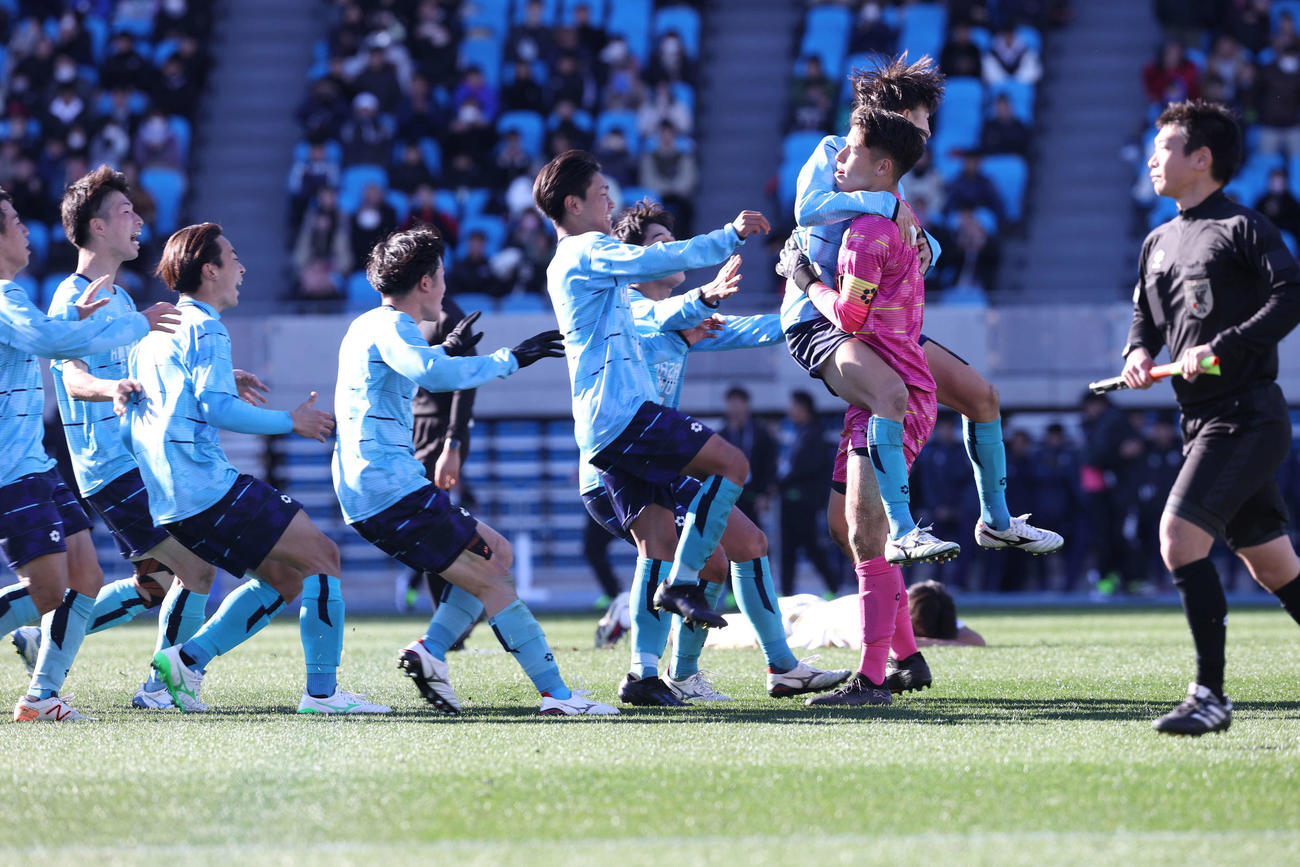 鹿児島城西対金沢学院大附PK戦を制し喜びを爆発させる金沢学院大附GK石山（右から2人目）ら金沢学院大附イレブン。後方はPKを外した鹿児島城西・大石（撮影・水谷安孝）