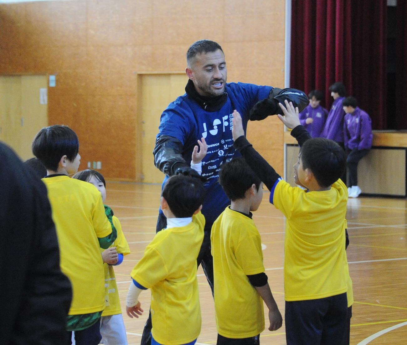 24年12月、サッカー教室で子どもたちとタッチする舞行龍ジェームズ（撮影・小林忠）