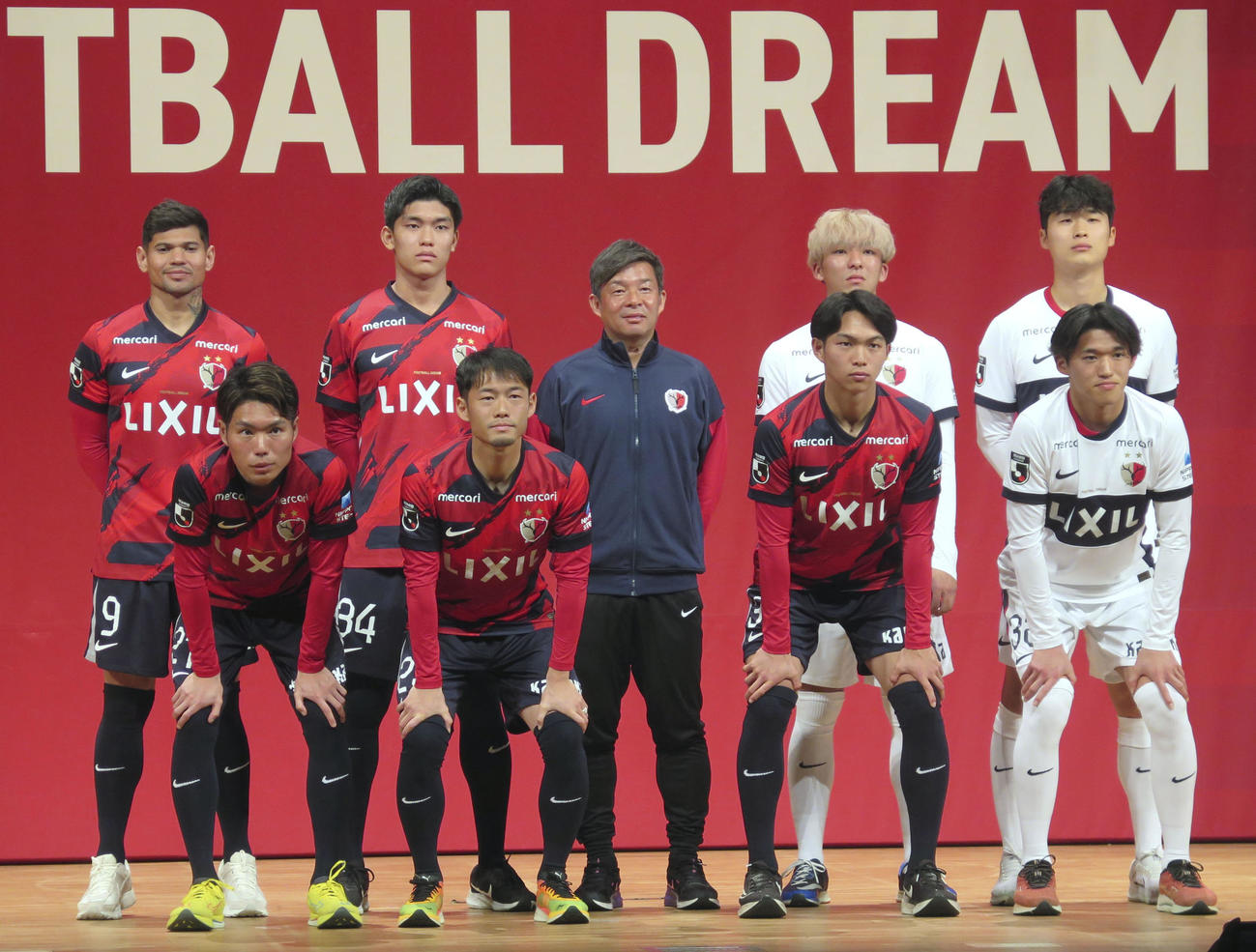 J1鹿島の新体制発表会で、写真に納まる鬼木監督（中央）ら（共同）