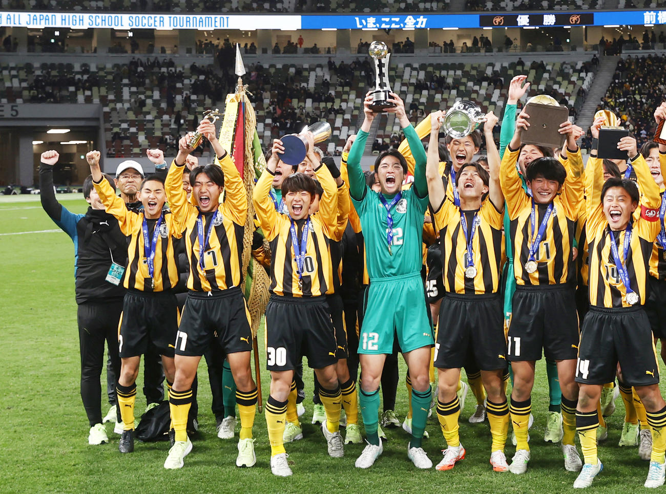 7大会ぶり2度目の優勝を果たし、写真に納まる山田監督（左奥）と前橋育英の選手たち＝国立競技場（共同）