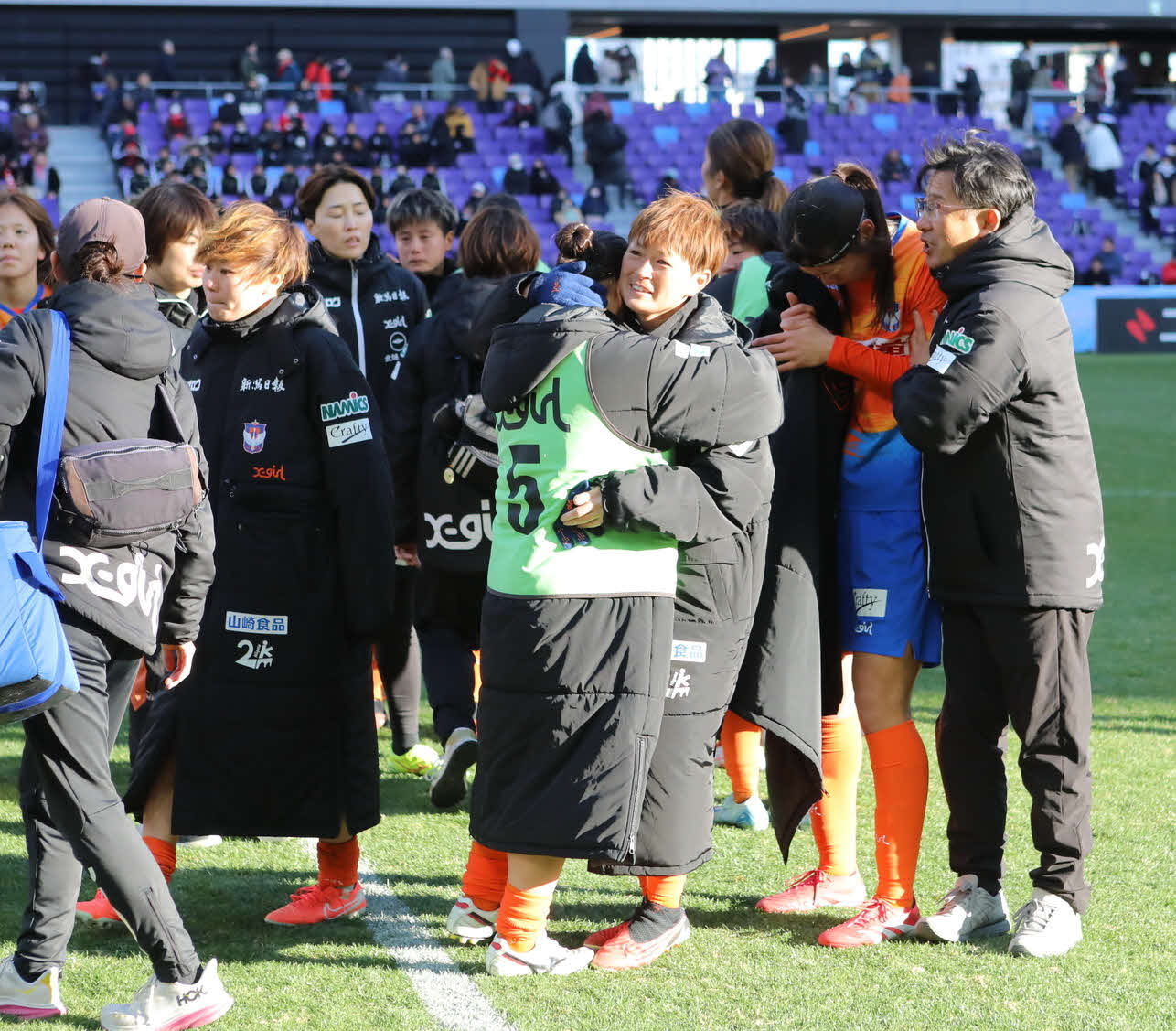 新潟対三菱重工浦和　試合に敗れ涙するチームメートをなぐさめる新潟上尾野辺（中央）（クラブ提供）