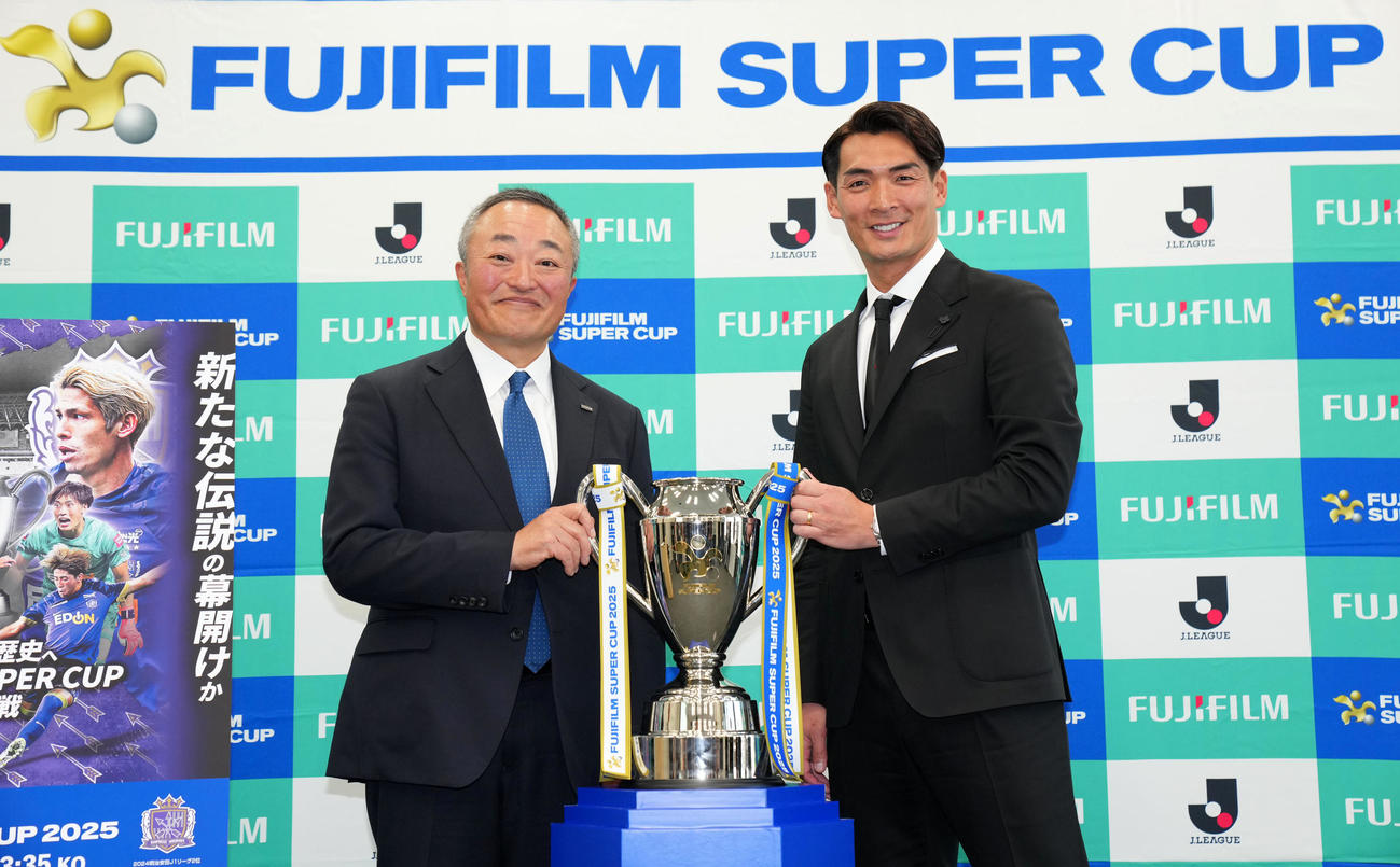 記者発表会で優勝杯を手に笑顔を見せる富士フイルムの浜直樹社長（左）と大会アンバサダーの槙野智章氏（撮影・横山健太）