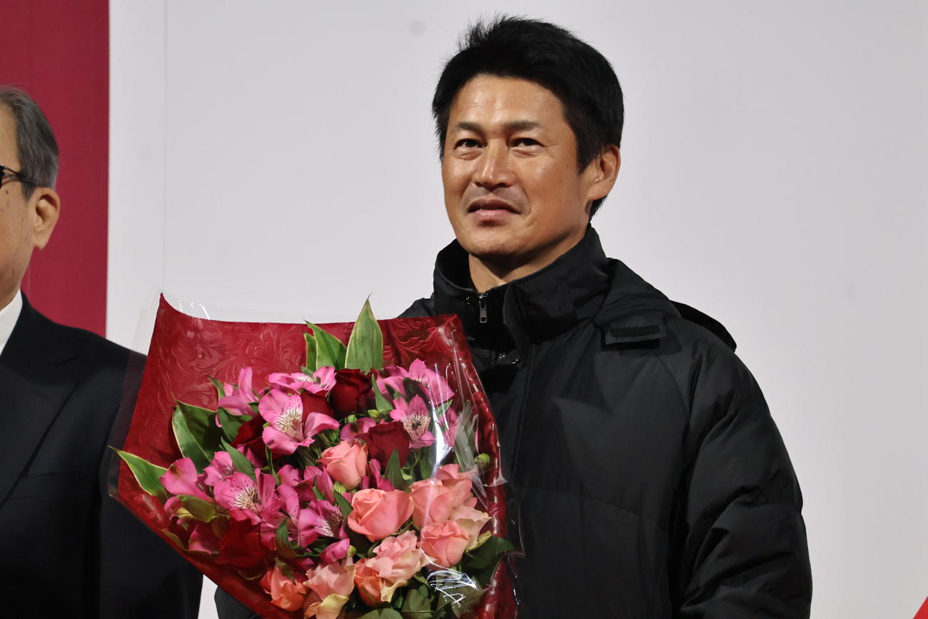 花束を持つ吉田孝行監督（撮影・竹本穂乃加）