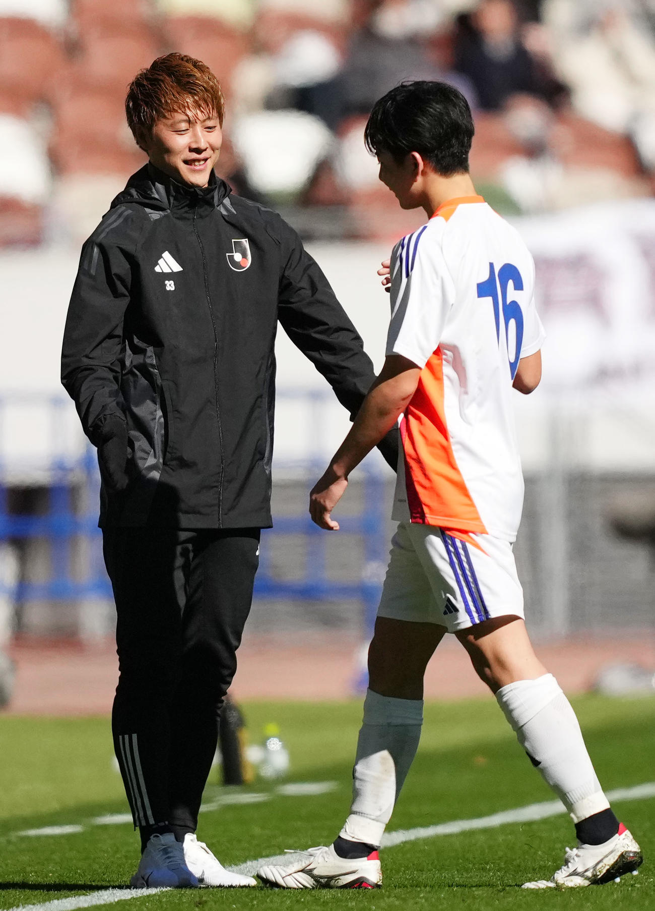 U18Jリーグ選抜対日本高校サッカー選抜　前半を終え、U18Jリーグ選抜長南（右）とタッチを交わす柿谷コーチ（撮影・横山健太）