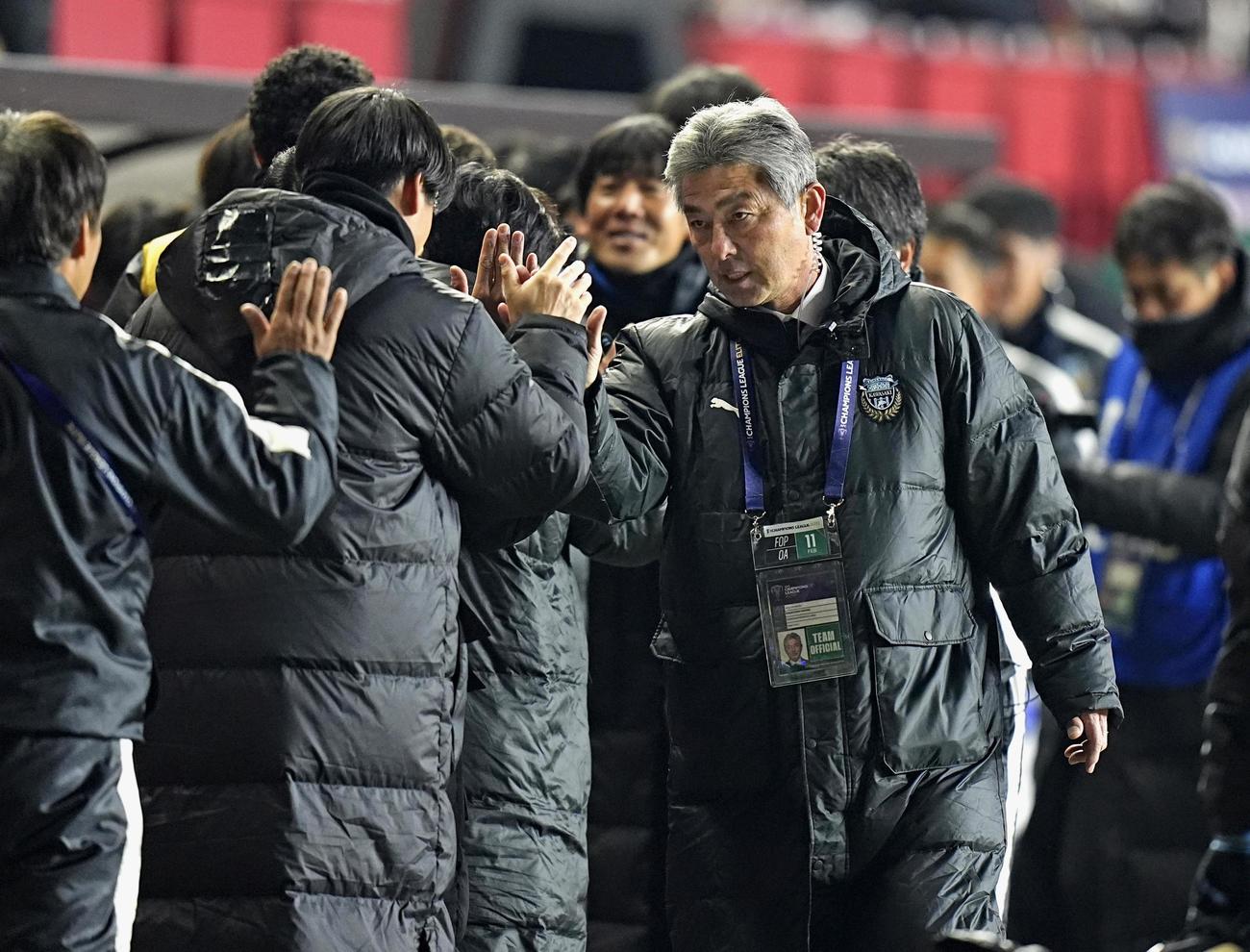 浦項に快勝し、タッチを交わす川崎・長谷部監督（右）。決勝トーナメント進出を決めた＝浦項（共同）