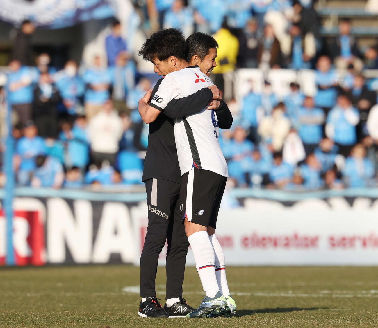 横浜FC対東京　東京高（手前）と勝利の抱擁をかわす松橋監督（撮影・宮地輝）