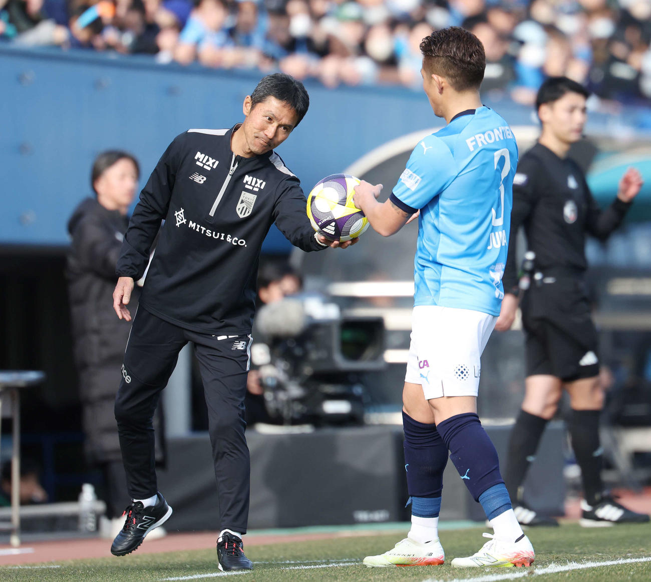 横浜FC対東京　前半、スローインのボールを横浜FC鈴木準（右）に手渡しする東京松橋監督（撮影・宮地輝）