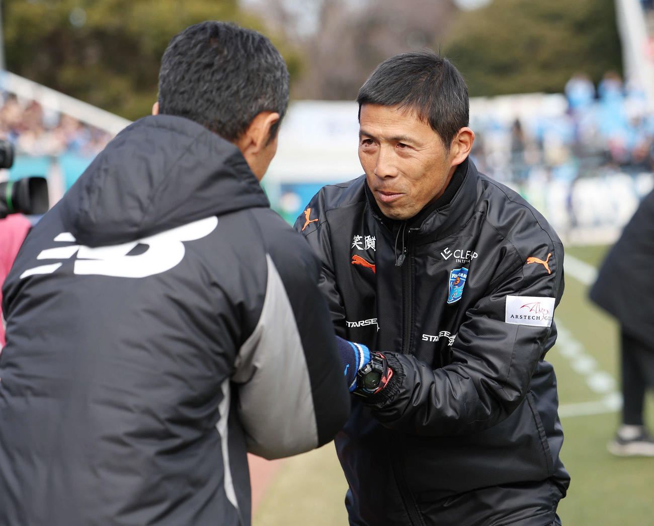 横浜FC対東京　試合前、東京松橋監督（左）と握手を交わす横浜FC四方田監督（撮影・宮地輝）