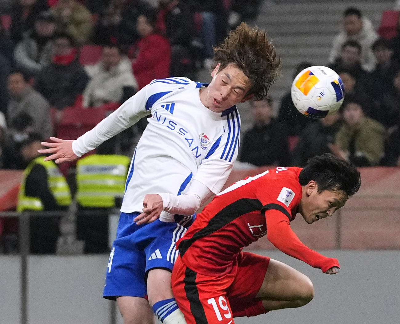 横浜M―上海海港　後半、空中で競り合う横浜M・植中（左）＝上海（共同）