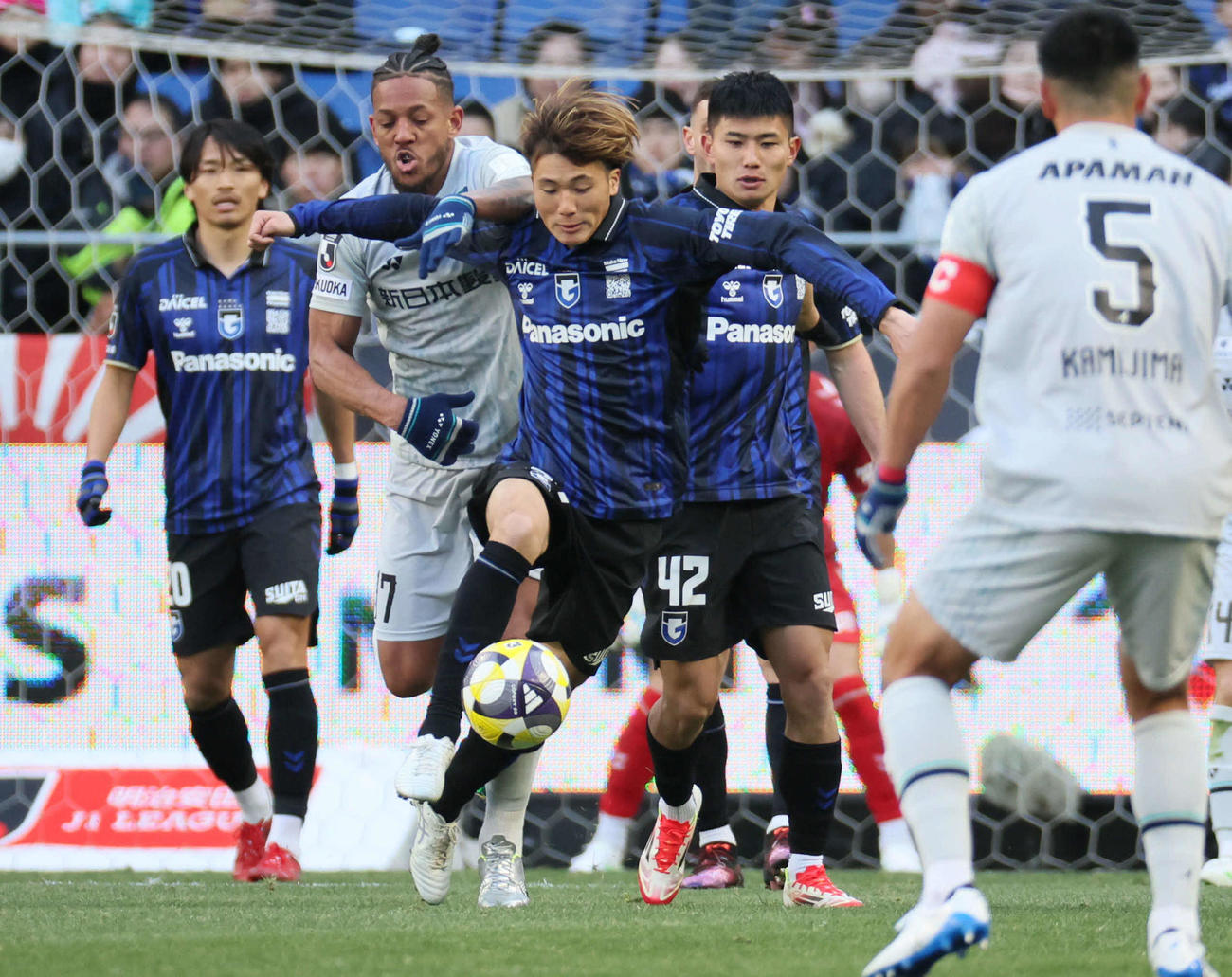 G大阪対福岡　後半、G大阪美藤倫（中央）は福岡ウェリントン（左から2人目）と激しく競り合う（撮影・宮崎幸一）