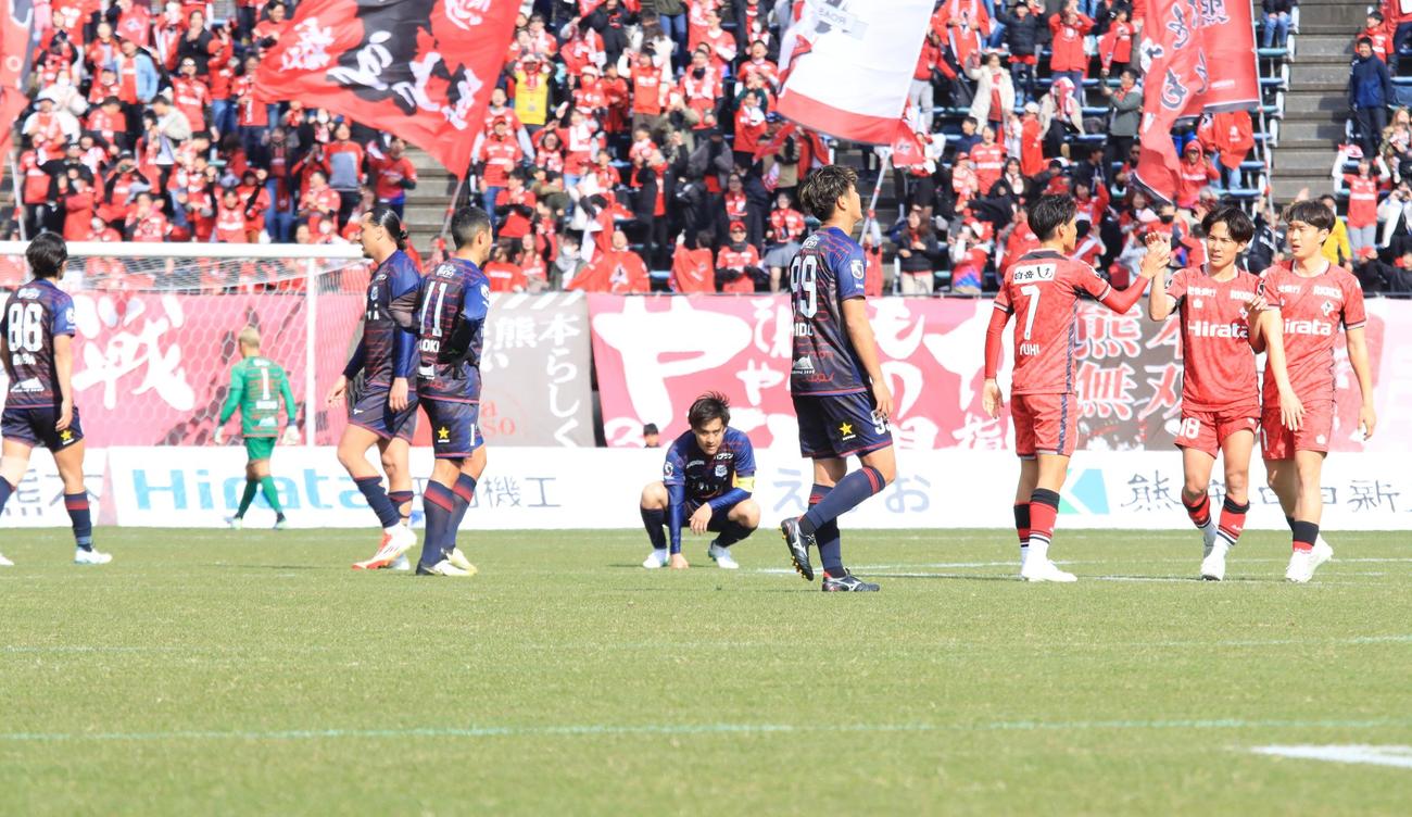 試合が終わり、うなだれる札幌の選手らと喜ぶ熊本の選手ら（撮影・保坂果那）