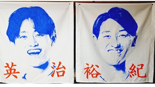 ゲーフラ見本。左から宮本、秋山（クラブ提供）