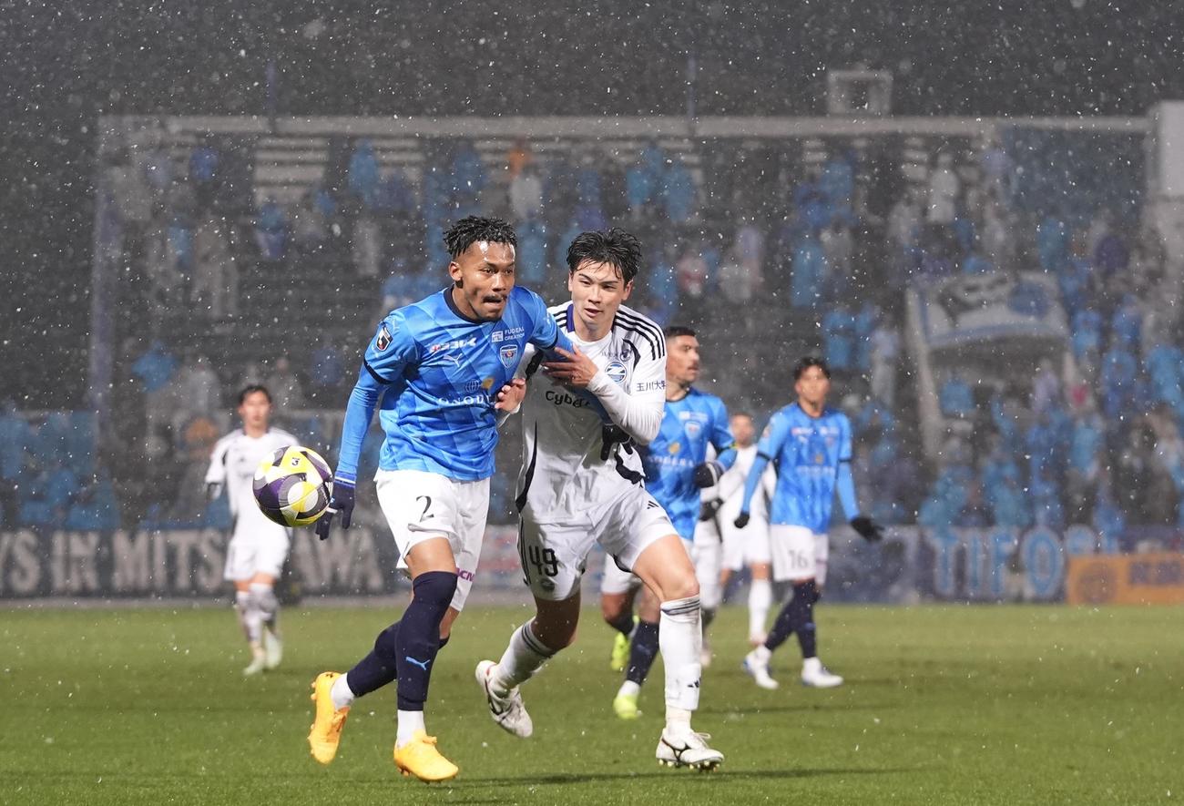 横浜FC対町田　後半、雪の舞うピッチで競り合う町田桑山（右）と横浜FCボニフェイス（撮影・垰建太）