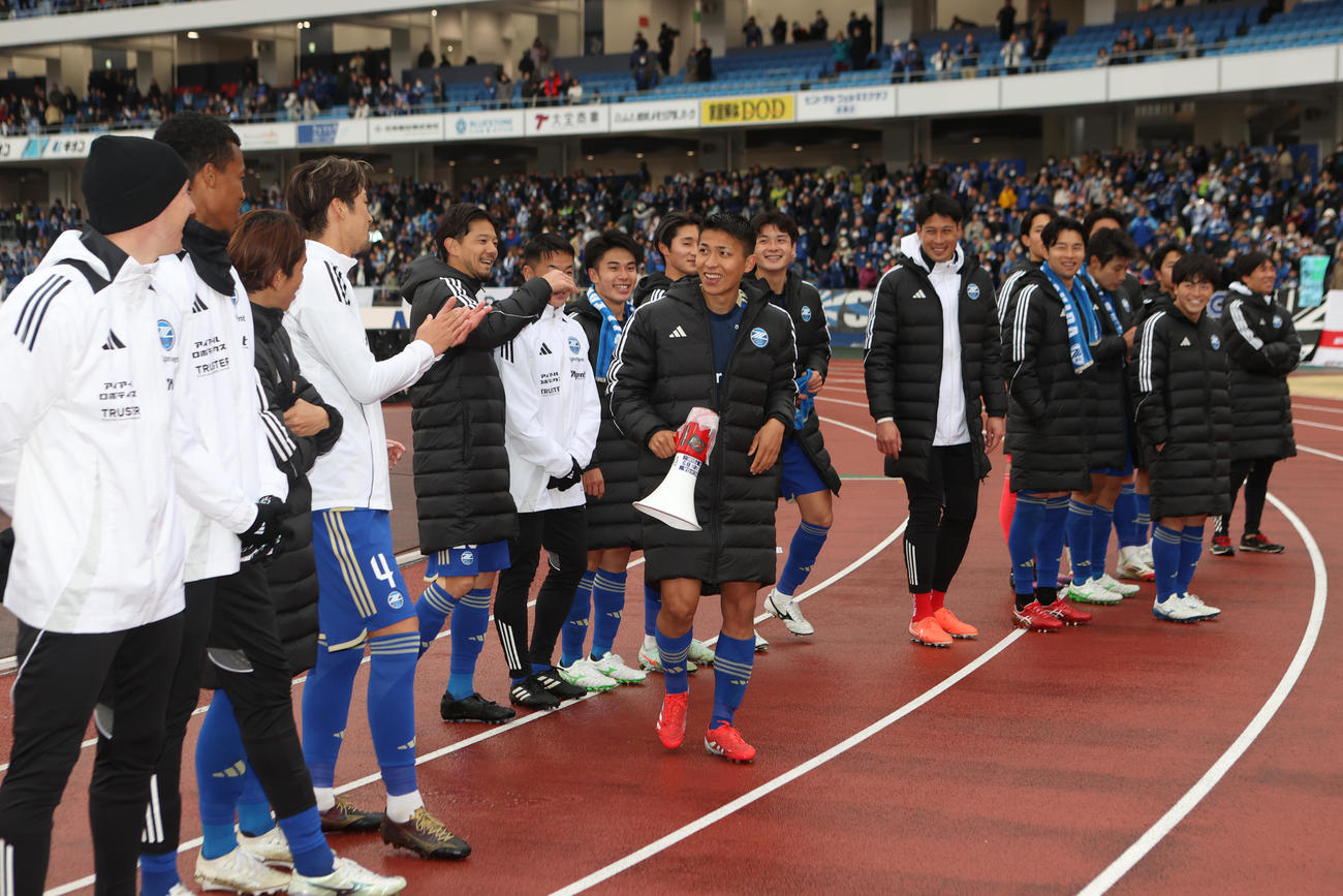 町田対新潟　拡声器を持ちサポーターへあいさつに向かう町田西村（中央）と町田イレブン（撮影・水谷安孝）