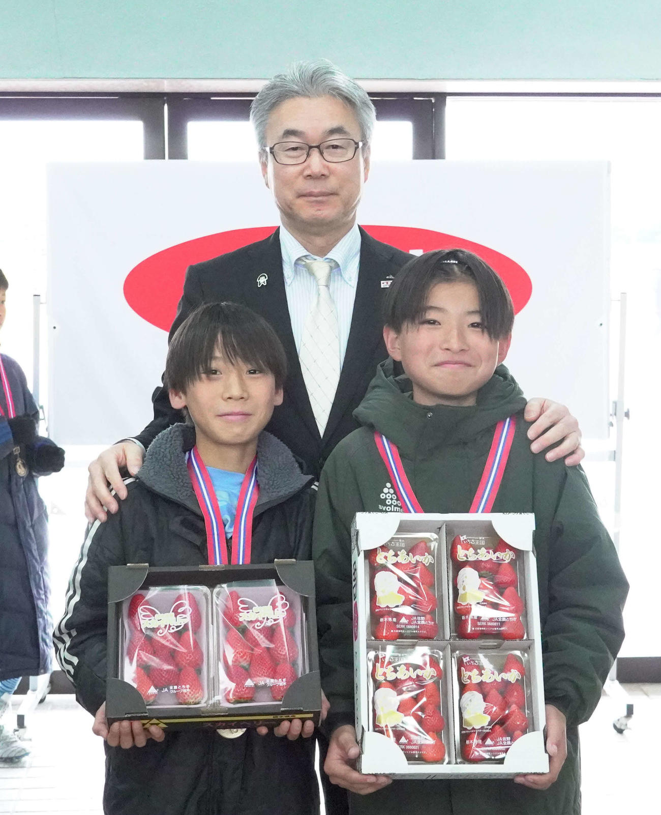 優勝チームに副賞を手渡した、JA全農とちぎの田波宏夫管理部部長（中央）