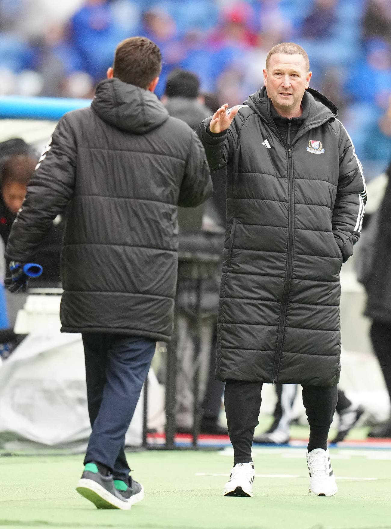 横浜対G大阪　試合後、G大阪ポヤトス監督（左）とあいさつを交わす横浜ホーランド監督（撮影・江口和貴）