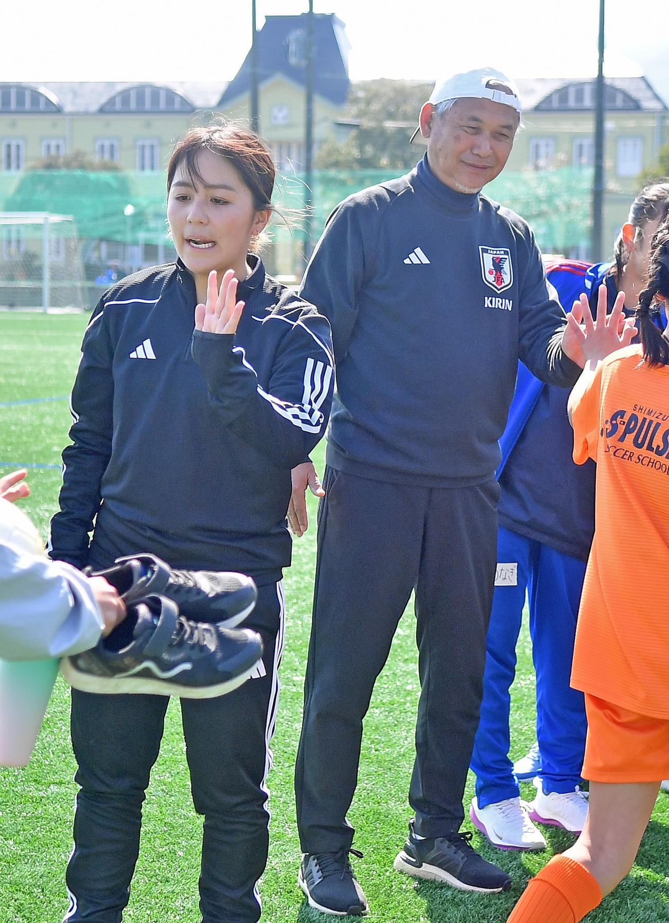 ハイタッチで参加者を見送る岩渕さんと日本サッカー協会の佐々木女子委員長