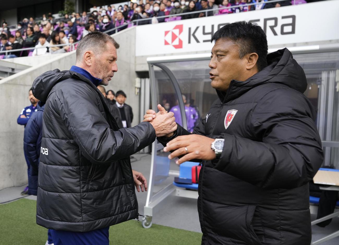 試合前、握手を交わす広島・スキッベ監督（左）と京都・曺貴裁監督（共同）