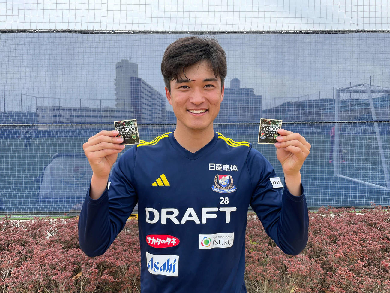 横浜MF山根は来場者に配布されるステッカーを手に笑顔で東京V戦をPR（横浜F・マリノス提供）